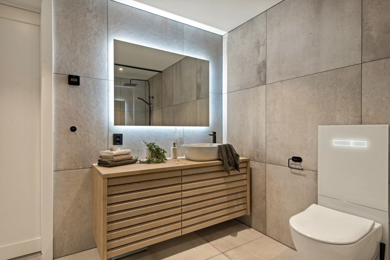 Kvalitetsinnredning i eik og speil med ledbelysning. Vannbåren gulvvarme og downlights i tak. Galleribilde