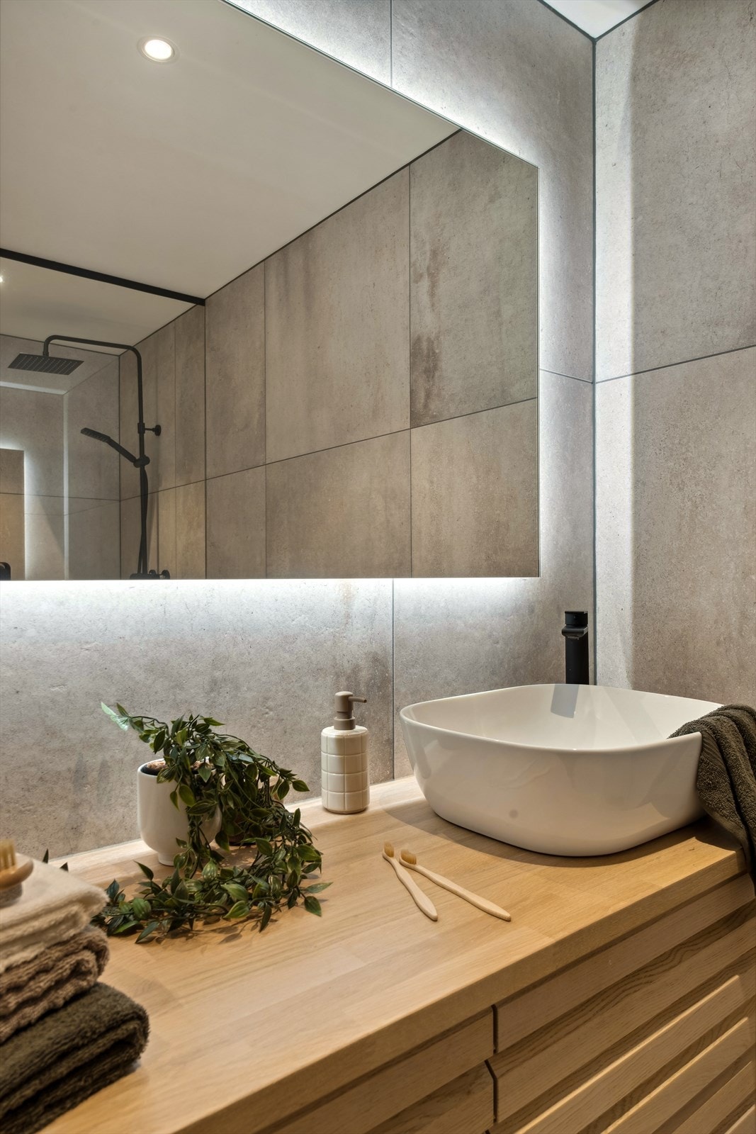 Også dette badet har lekker baderomsinnredning i eik med skuffeseksjon og speil med belysning. Galleribilde