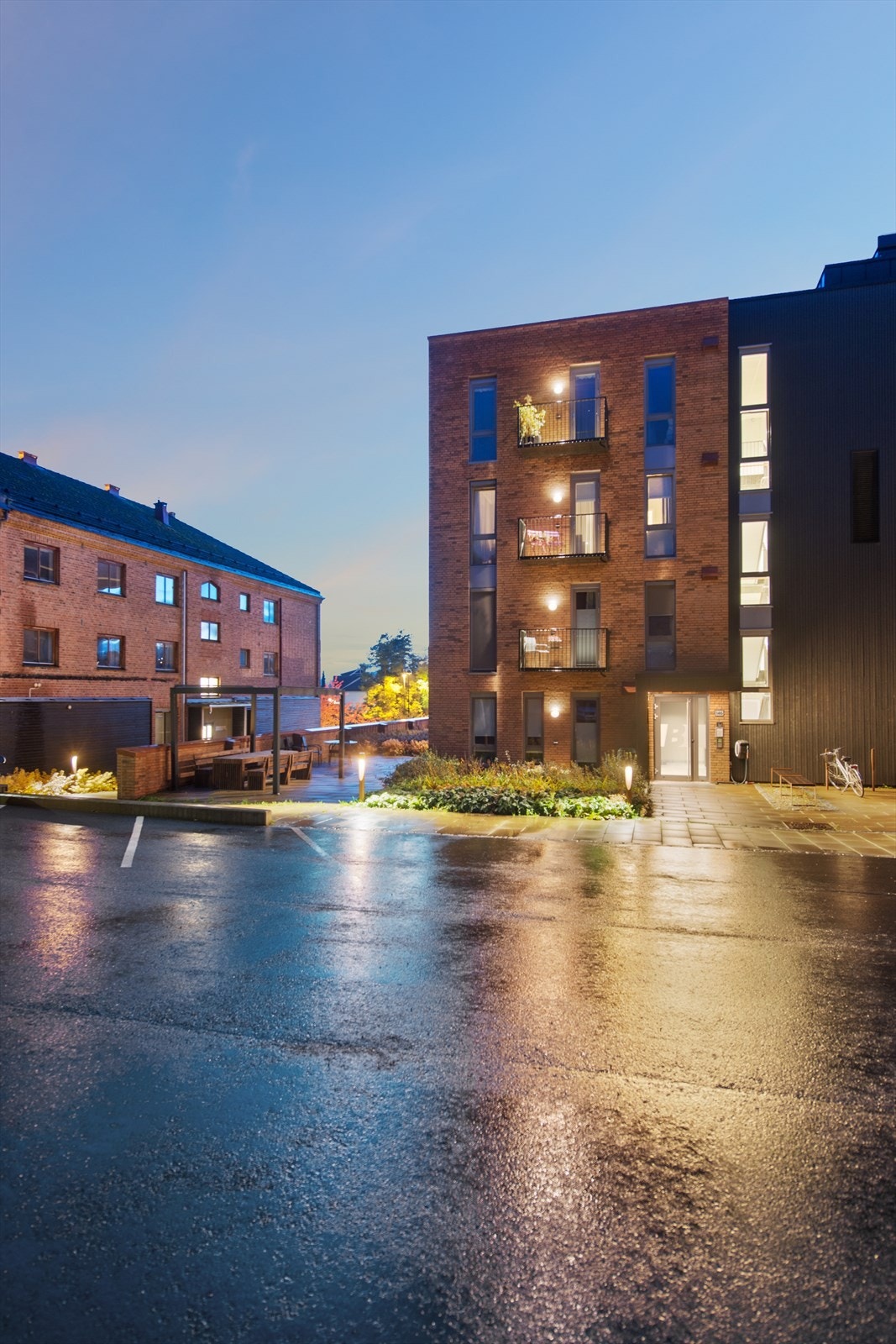 Hyggelig inngangsparti med felles uteområdet opparbeidet med stenlagt markterrasse, pergola og sittegruppe. Gjesteparkering. Galleribilde