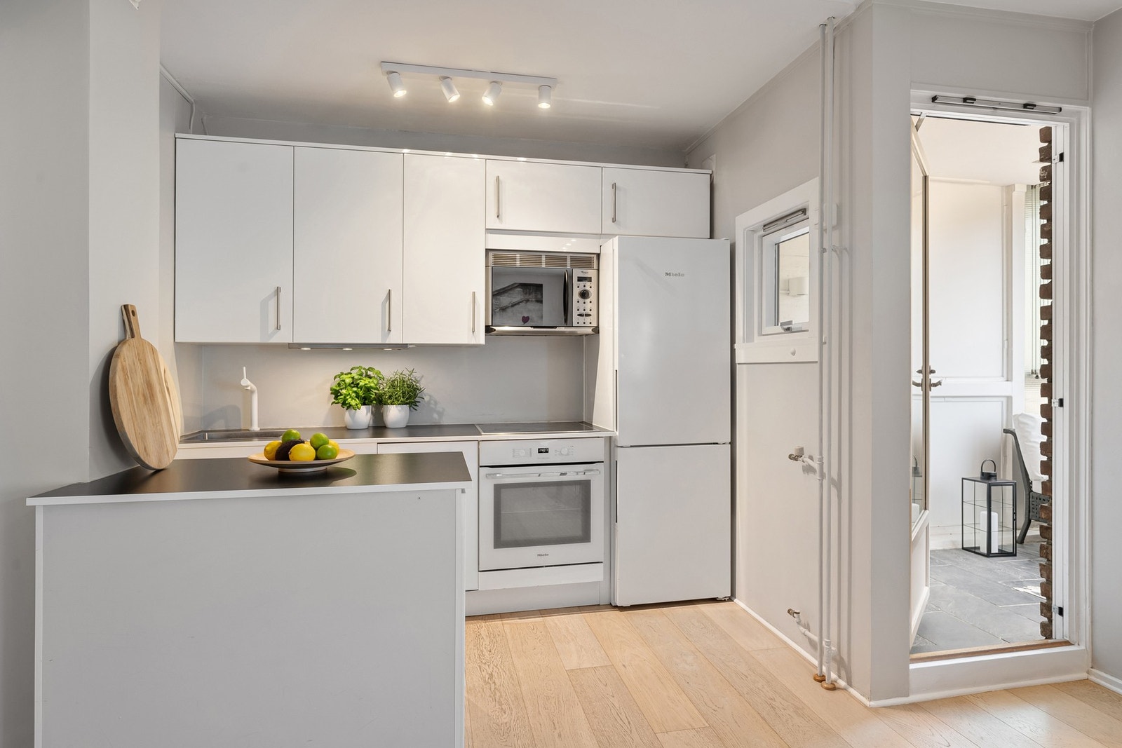 Tidløs og lys kjøkkeninnredning med rikelig skap- og benkeplass. Galleribilde