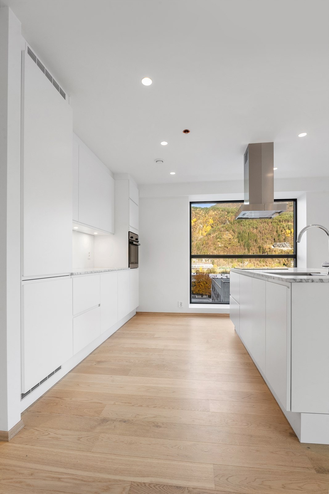 Kjøkkeninnredning med slette hvite fronter Galleribilde