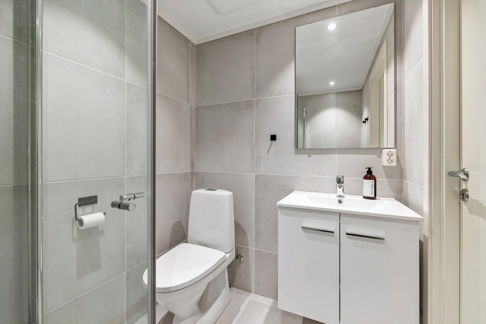 Moderne bad, med store fliser, dusjhjørne og baderomsinnredning. Galleribilde