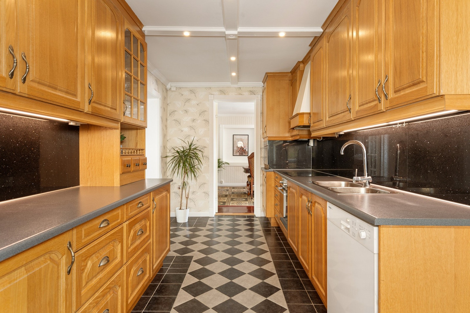 Kjøkkeninnredningen fra 2002 har profilerte fronter og laminat benkeplate med fliser over benk - Integrert platetopp og stekeovn Galleribilde