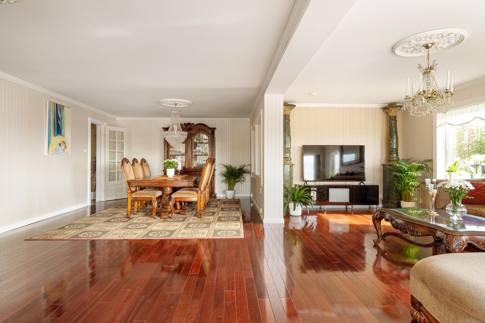 Flott og lys stue med parkettgulv og klassiske takrosetter Galleribilde