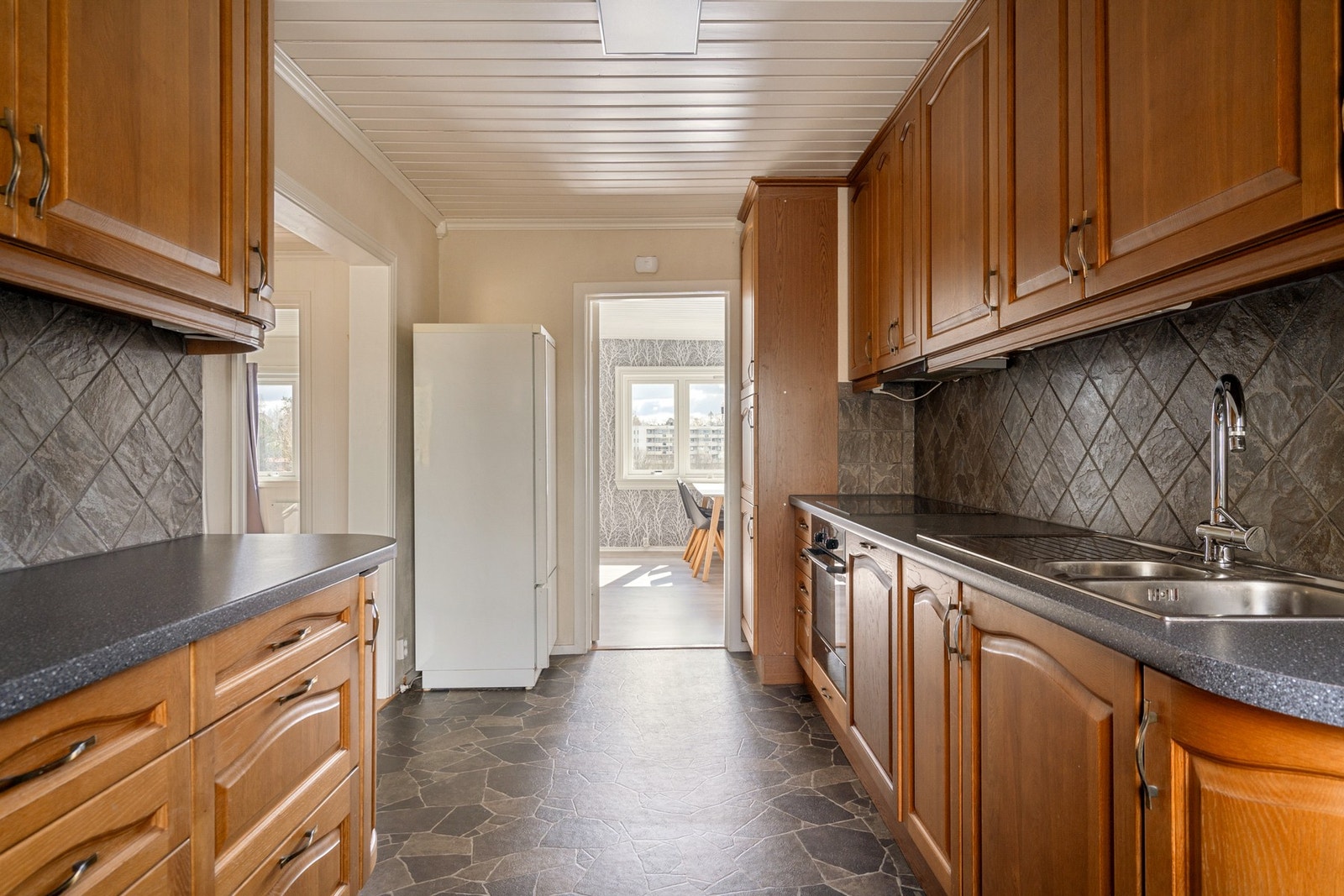 Kjøkkeninnredning fra 2008 med profilerte fronter, laminat benkeplate og oppvaskkum i stål - integrert platetopp og stekeovn Galleribilde