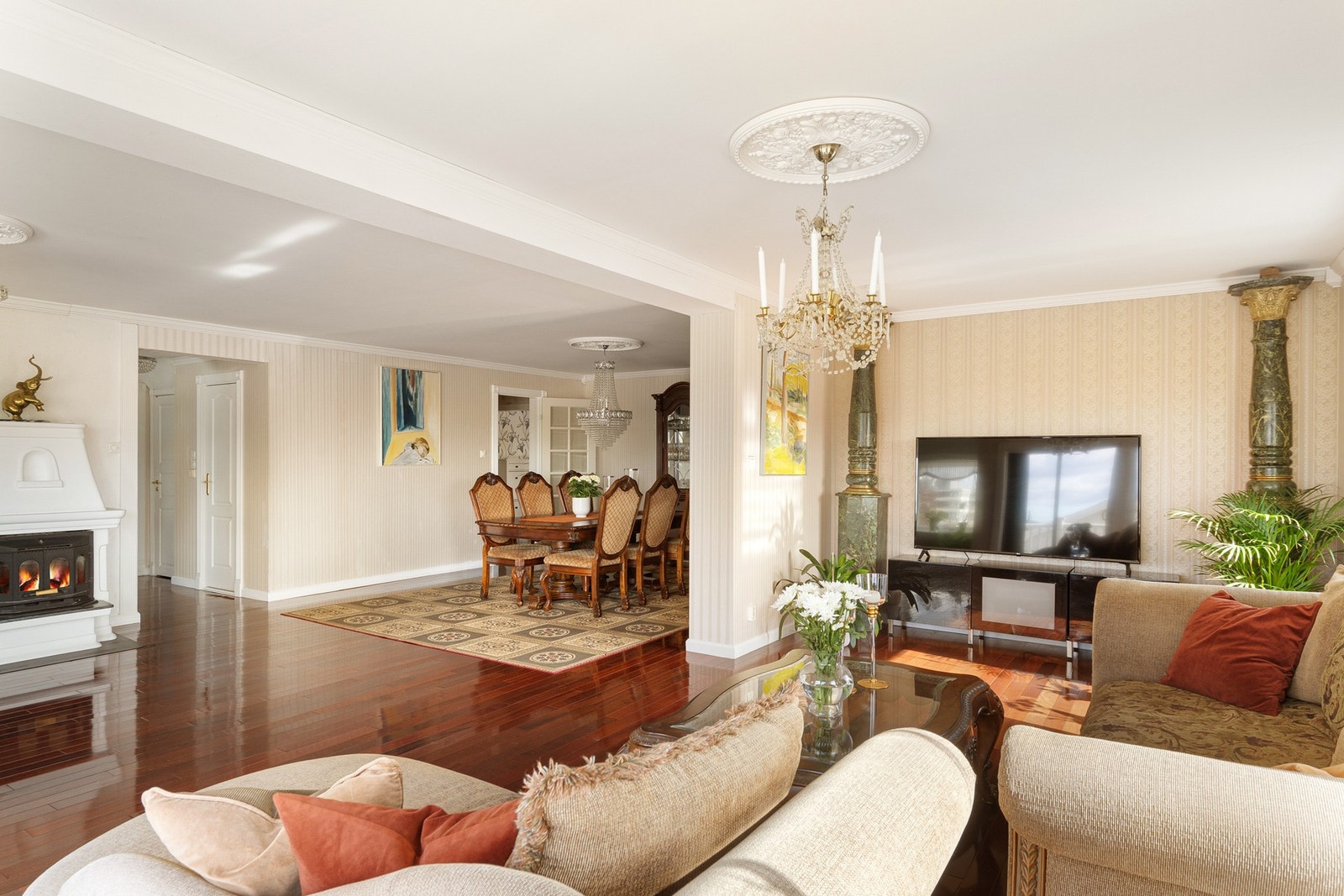 Flott og lys stue med parkettgulv og klassiske takrosetter Galleribilde