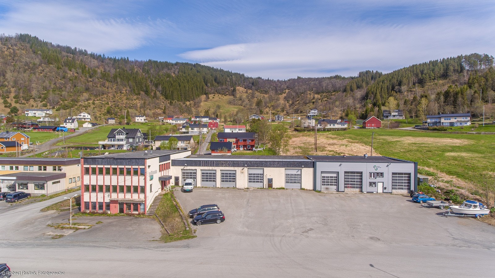Stor næringseiendom med utviklingspotensiale sentralt i Vangsvik. Bygget til høyre med grå fasade inngår ikke i salget. Galleribilde