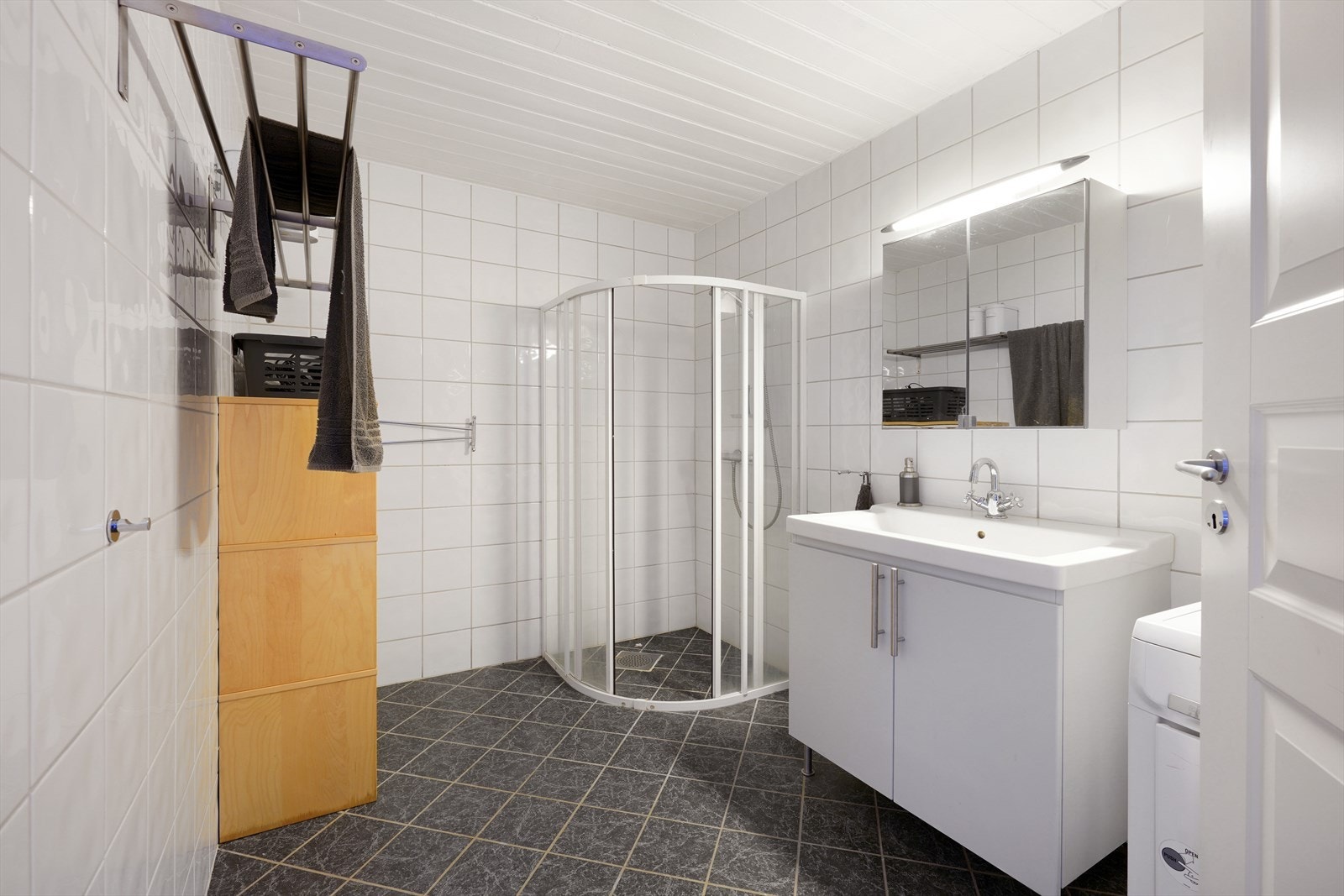 Romslig bad med dusjkabinett, flisebelagte vegger og gulv. Opplegg for vaskemaskin. Galleribilde