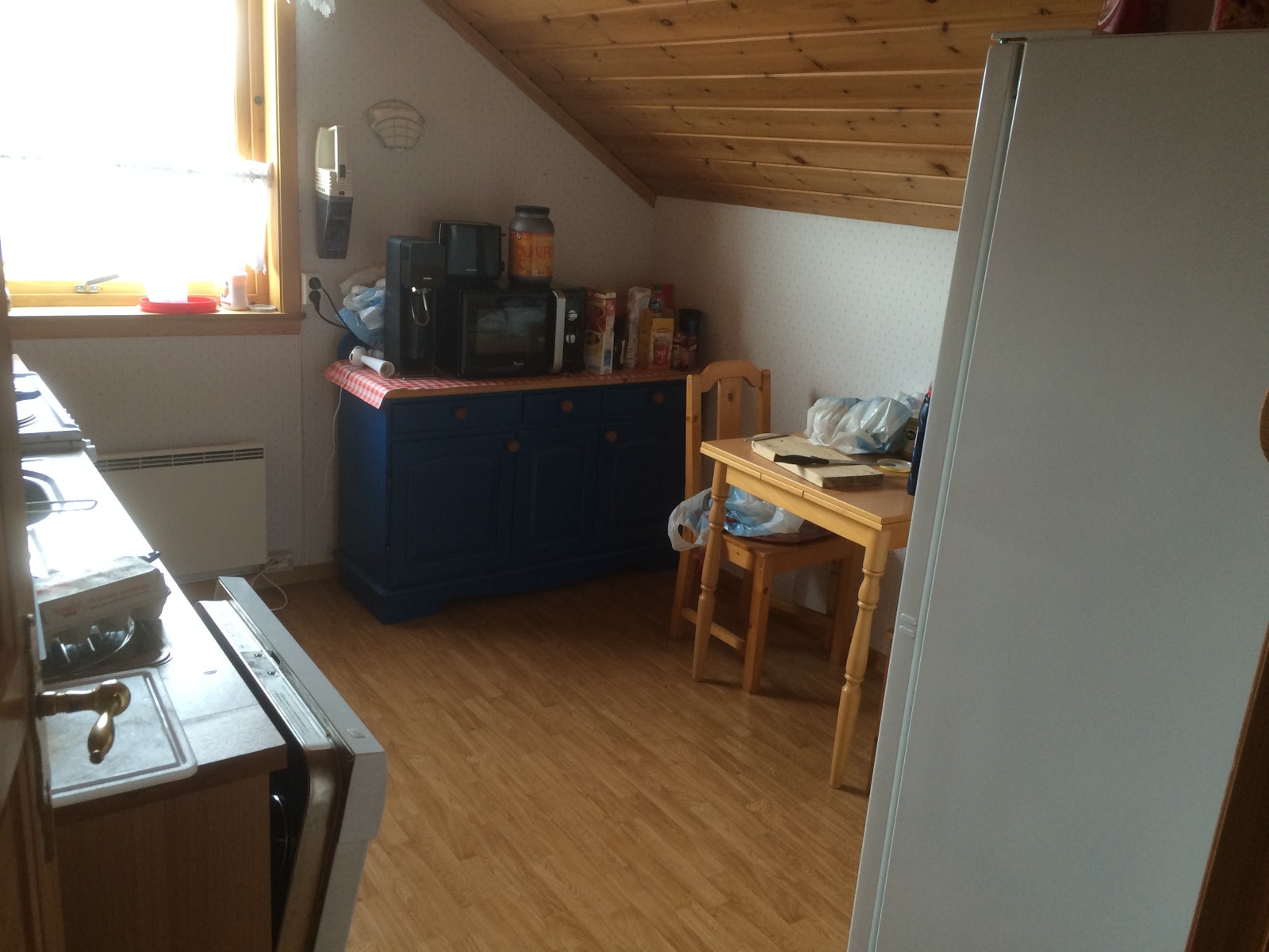 Koselig kjøkken med kjøleskap, komfyr, oppvaskmaskin, fryser, mikrobølgeovn Galleribilde