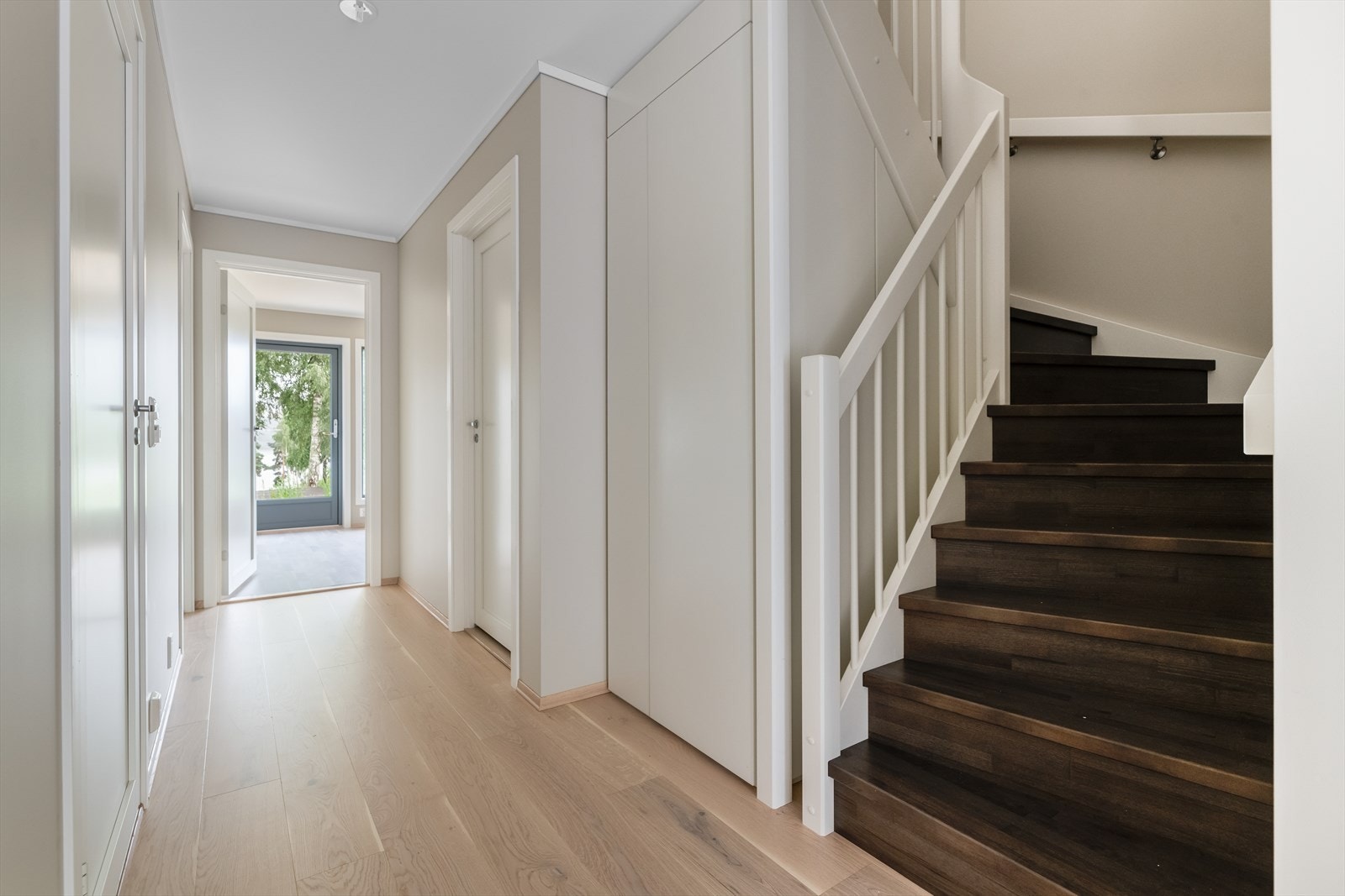 Stilfull trapp mellom etasjene, med praktisk oppbevaringsrom under. Galleribilde