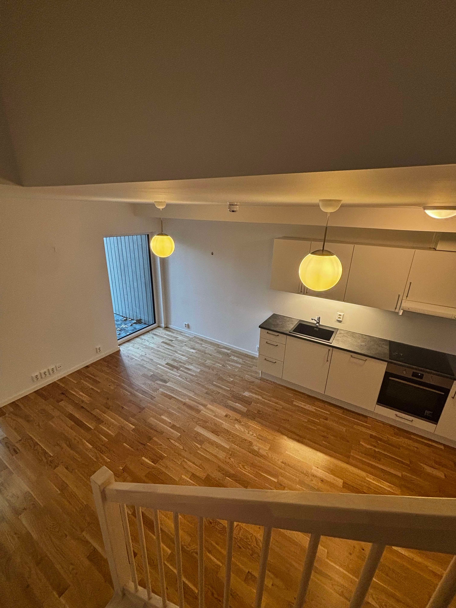 Rommet er lyst og har plass til både sofa seksjon og et spisebord ved kjøkkenet Galleribilde