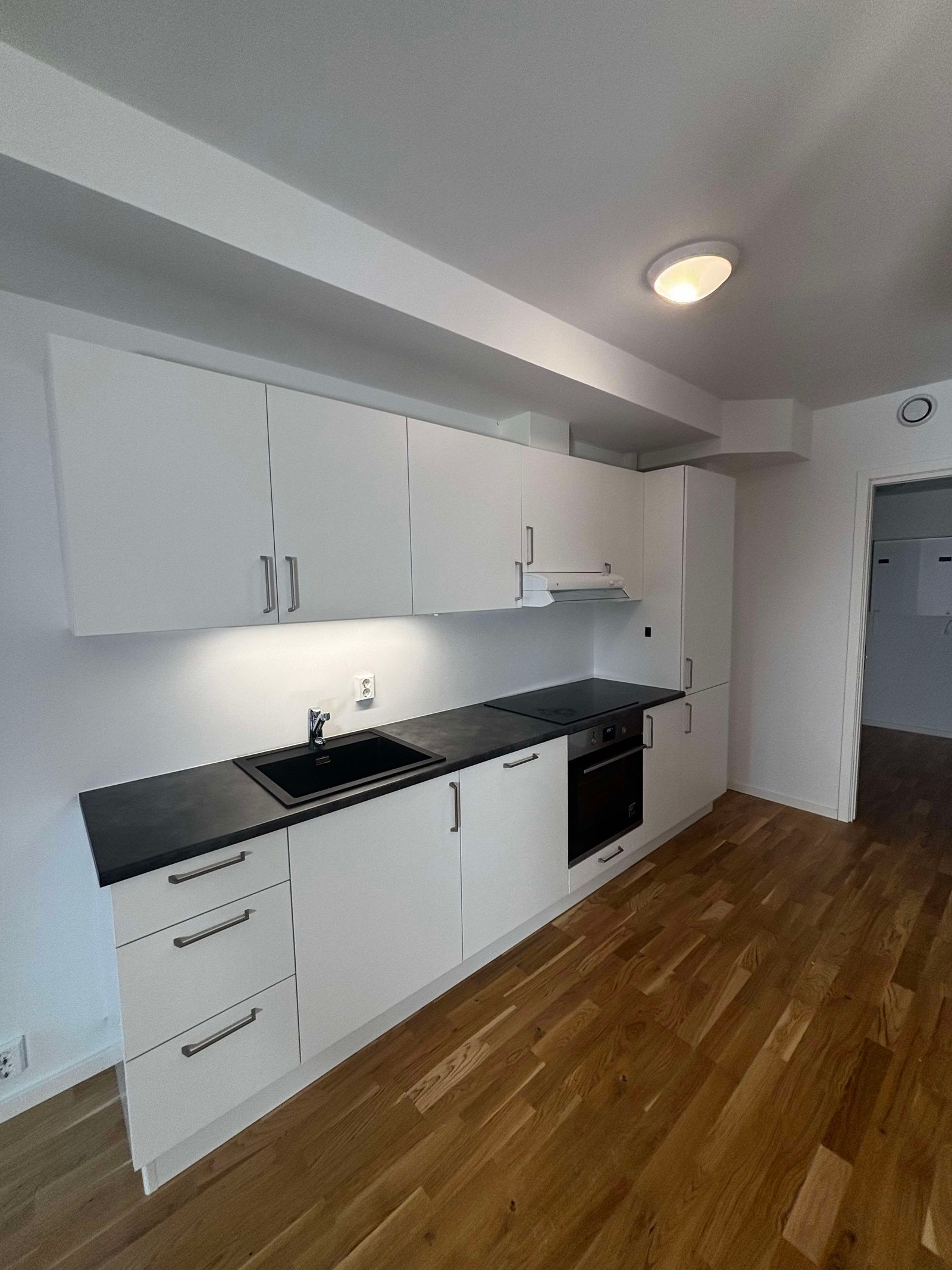 Kjøkkenet har lys, pen innredning og integrerte hvitevarer. Galleribilde