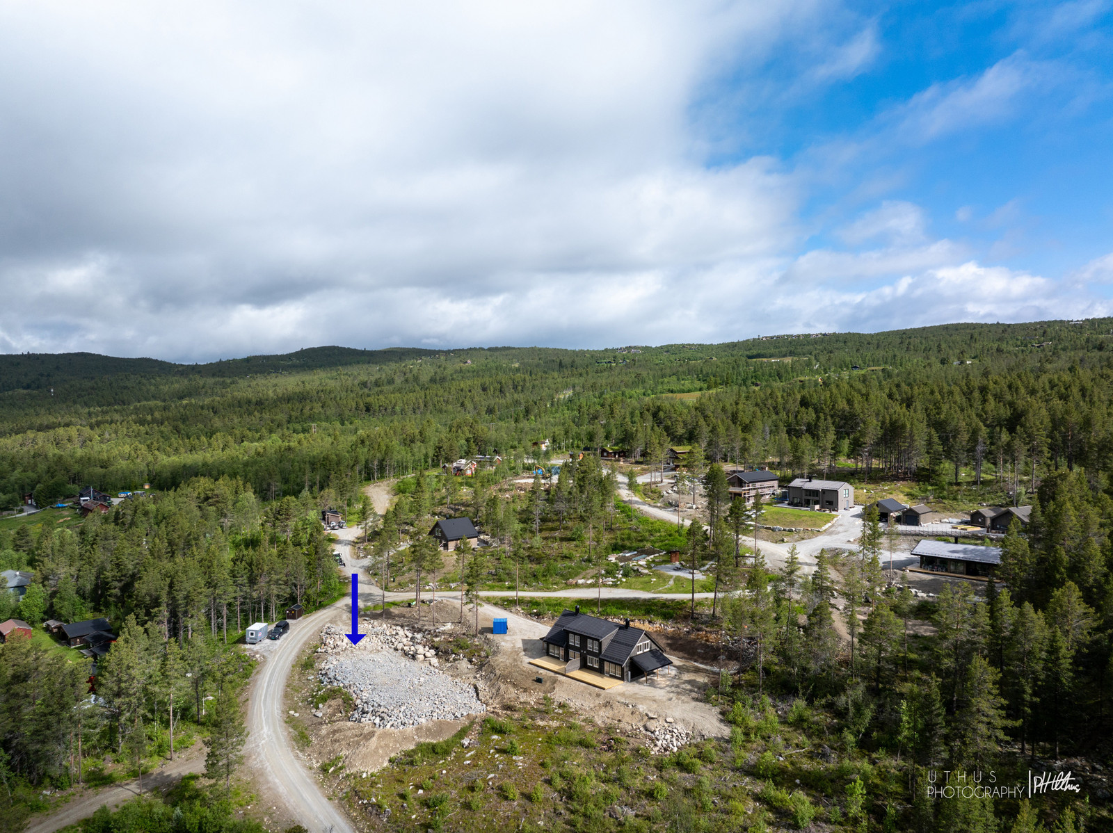 Bilder av tomteområdet, markert med blå pil