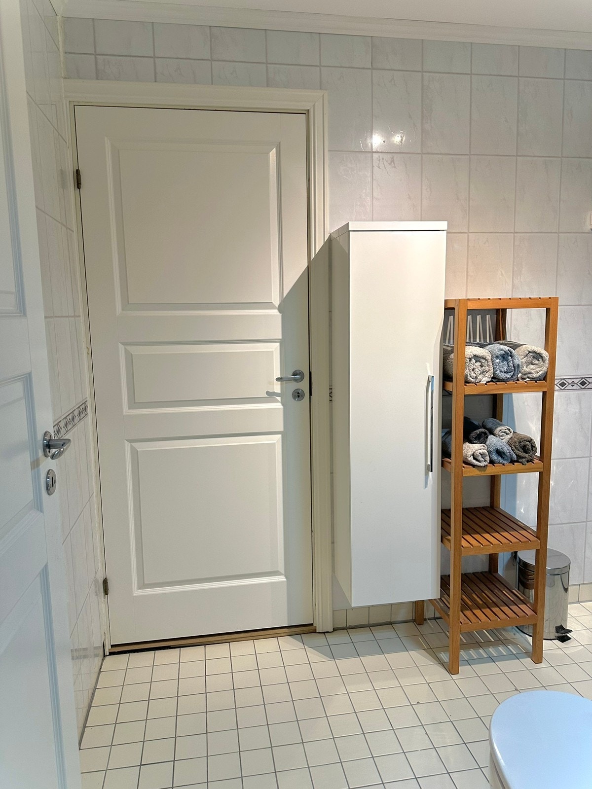 Romslig bad - med dør til en oppbevaringsbod, vegghengt skap Galleribilde