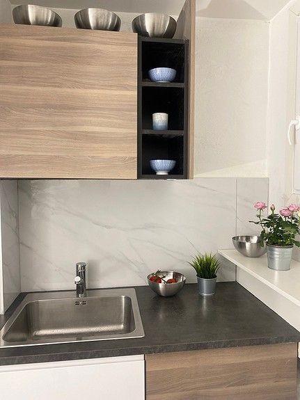 Kjøkkenet fremstår som moderne og nyoppusset med lekre fliser og har en arealeffektiv løsning. Galleribilde