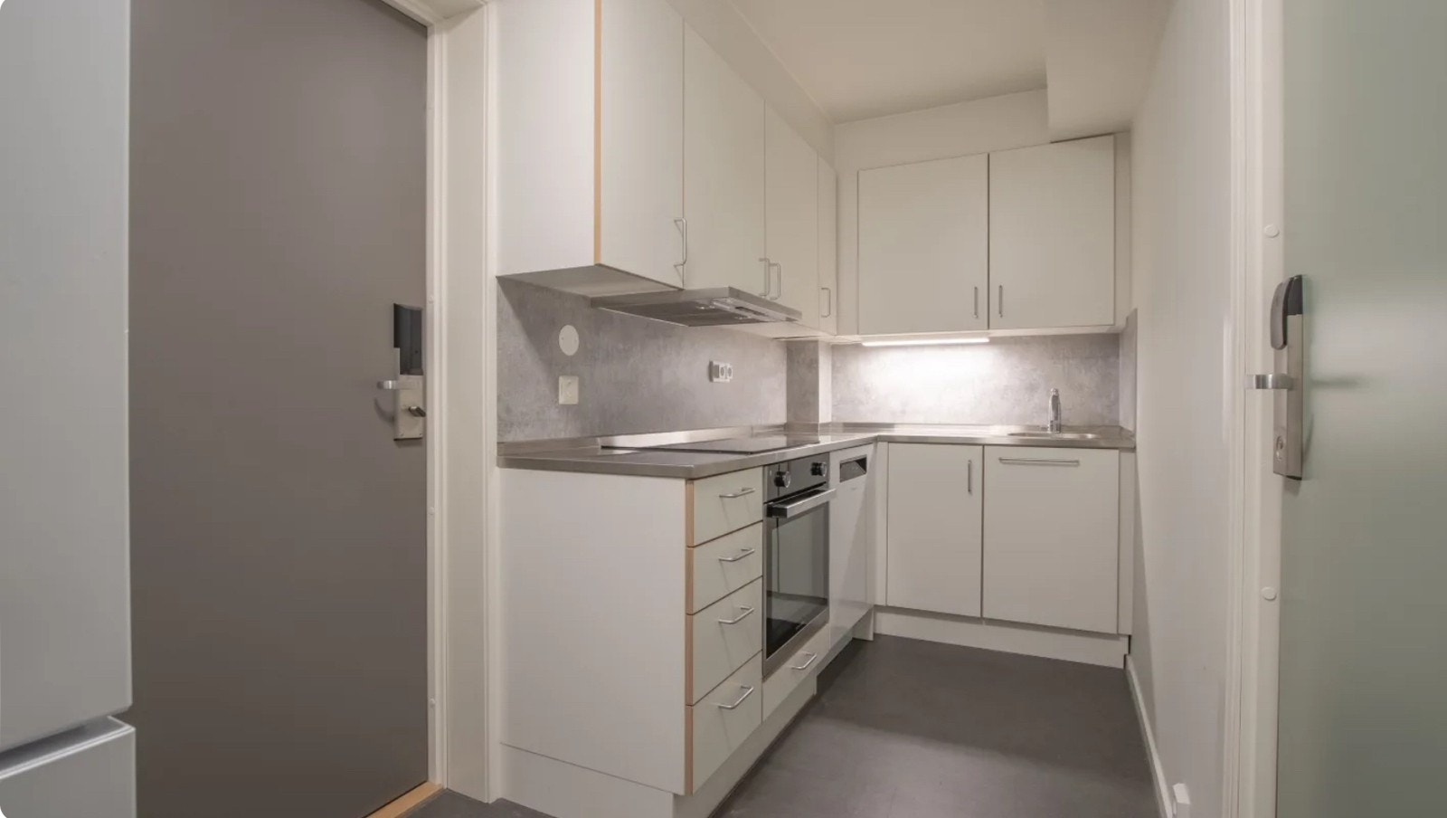 Kjøkkenet delt med en annen person. Grå dør er dør ut til gangen, grønn dør er dør inn til nabo/roomie, vi står her ved bad-døra og døra til hybelen. Galleribilde