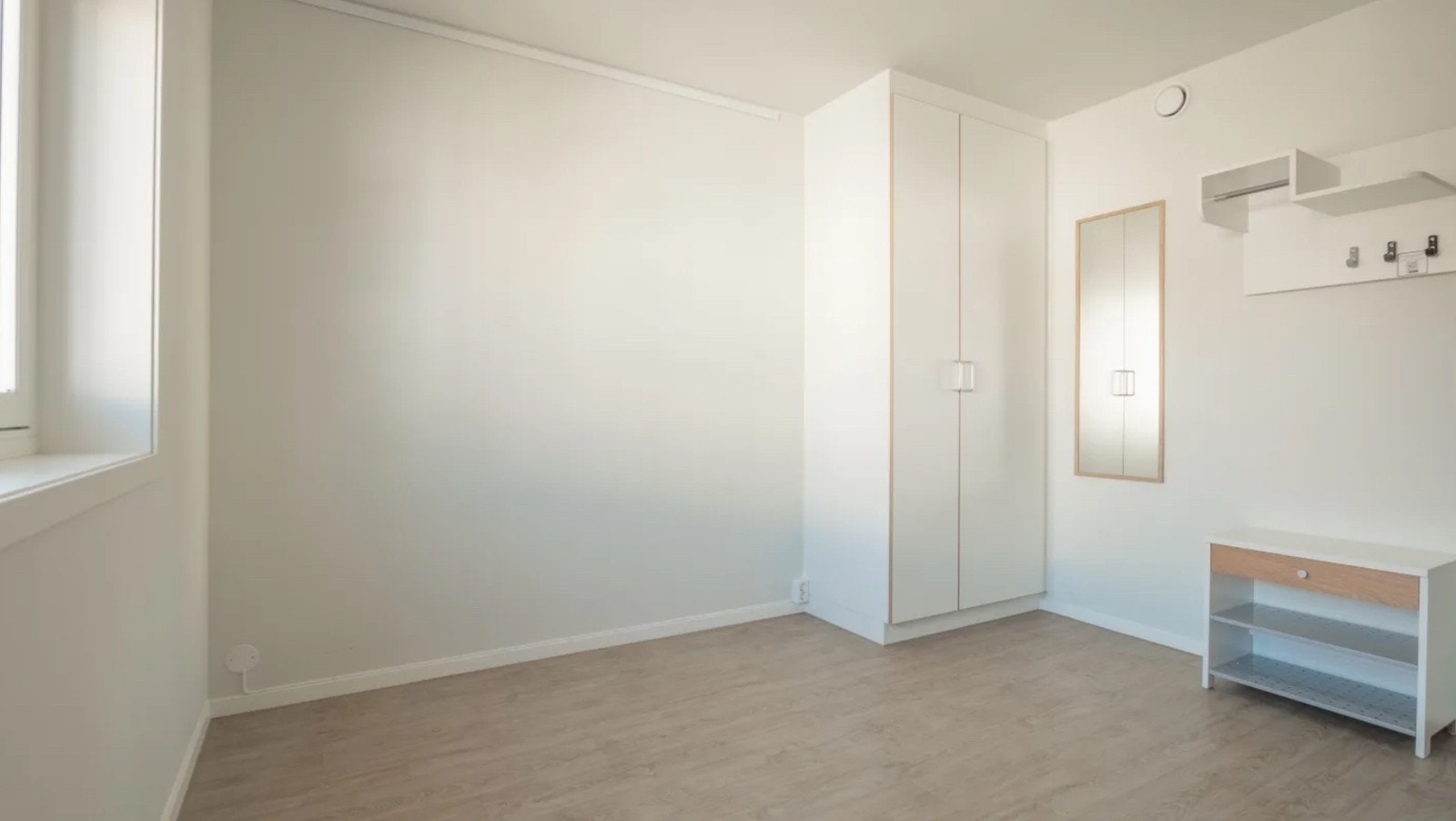 Her ser du veggen der sengen er plassert langs og klesskapet. Langt speil og skohylle. Knagger og hylle til yttertøy. Galleribilde