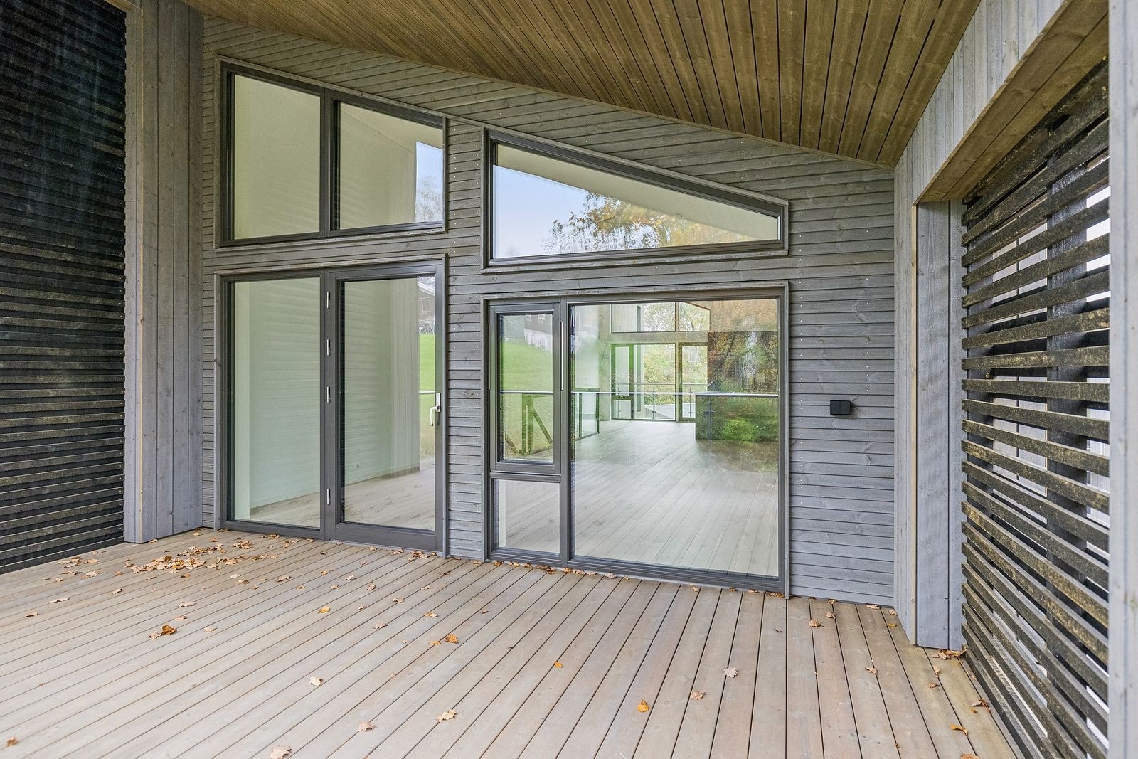 Stor stue med utgang til overbygd veranda. Perfekt for avslapning og sosiale sammenkomster, uansett vær. Galleribilde