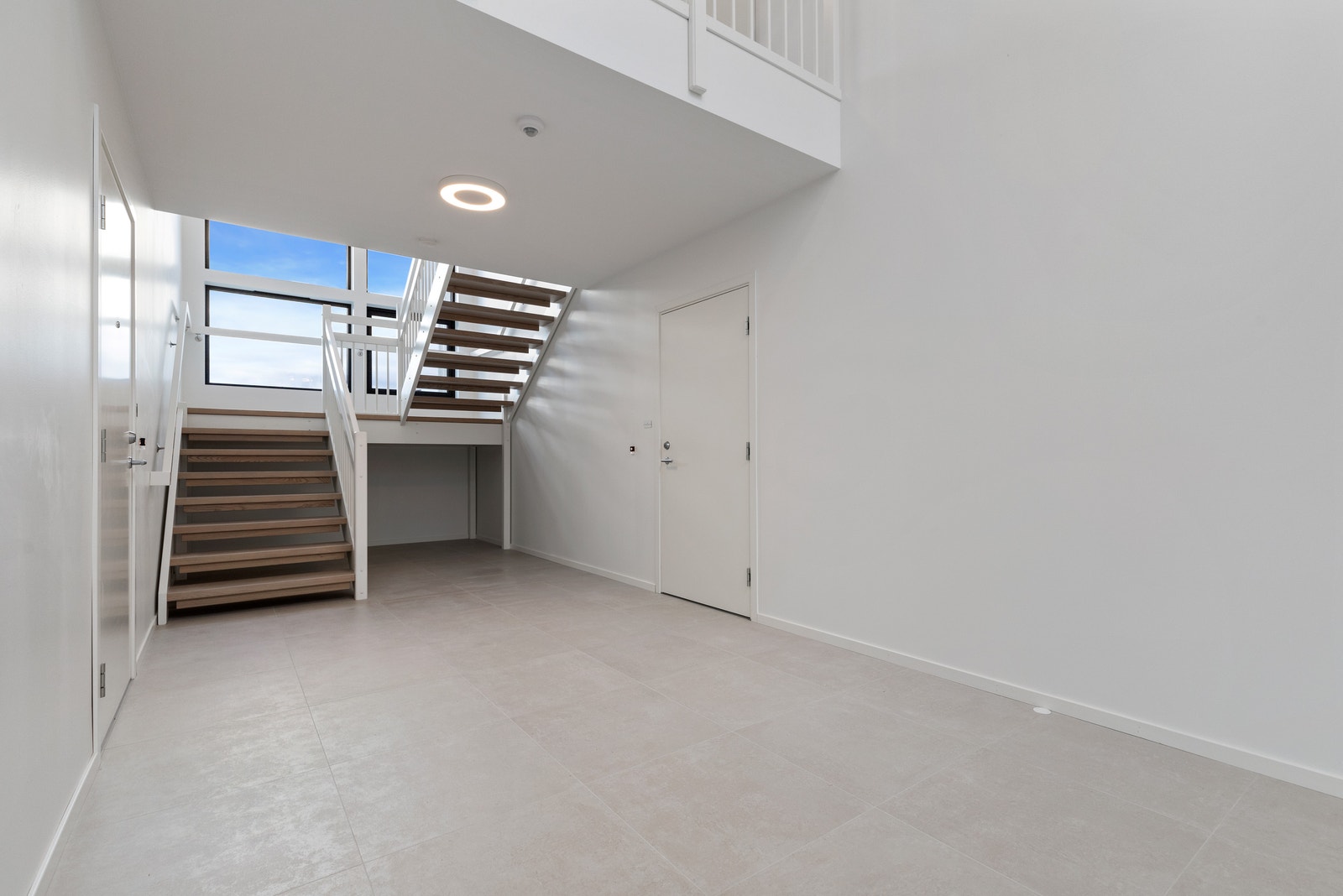 Felles trapperom. Flislagt i delikat farge og med innvendig kvalitetstrapp fra Stryntrappa. Galleribilde