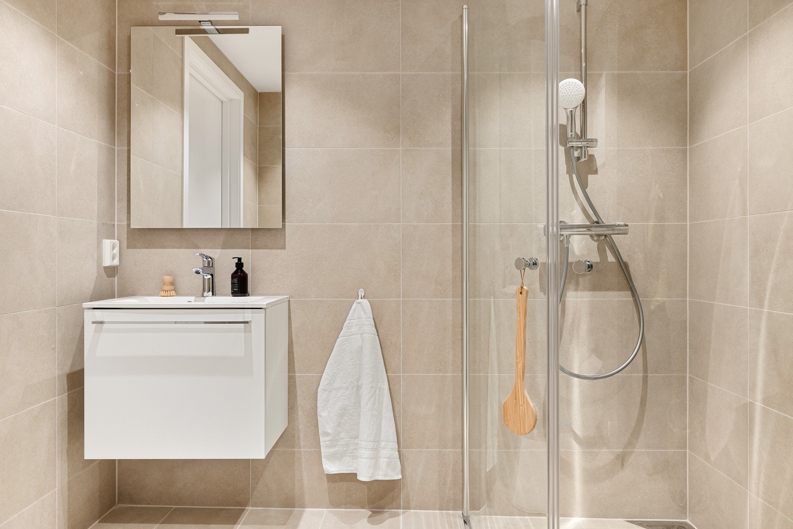 Begge badene er flislagt med beige fliser og har moderne innredning. Galleribilde