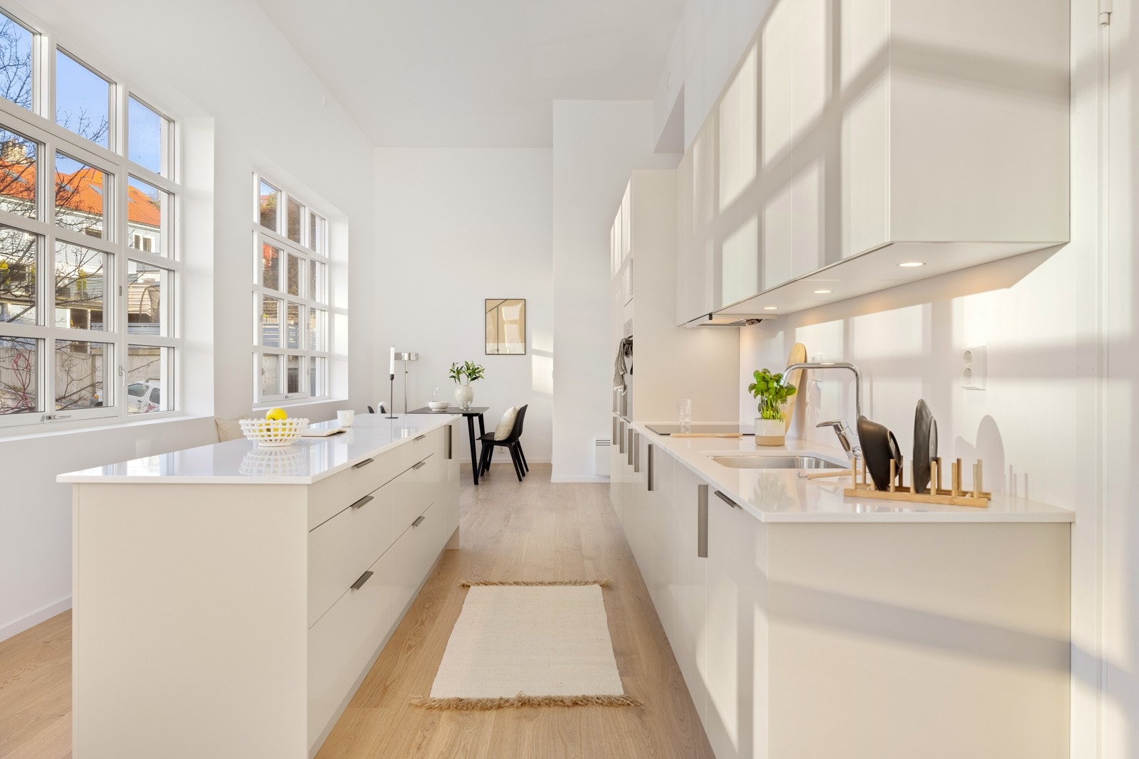 Stue og kjøkken ligger i åpen løsning, hvor kjøkkenet danner et naturlig skille mellom sofakroken og spisestuen. Galleribilde