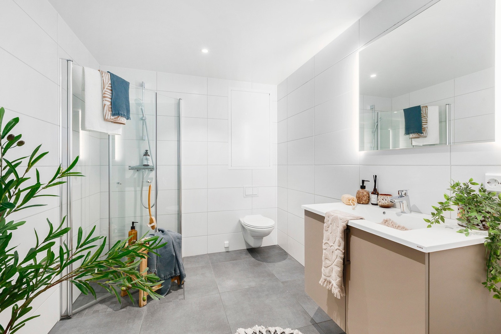 Baderom med flis på gulv og vegger, med en flott innredning. Galleribilde