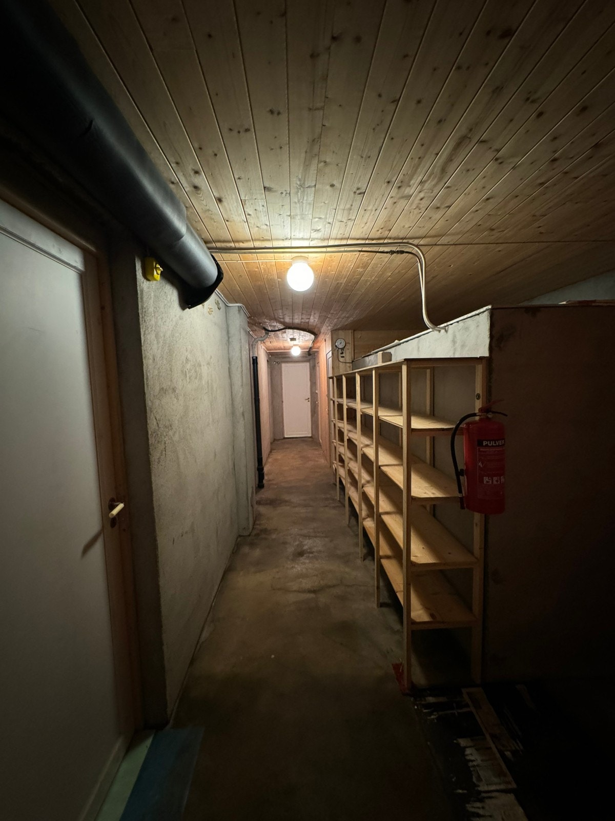 Gang i kjeller med mye hyller til lagring Galleribilde