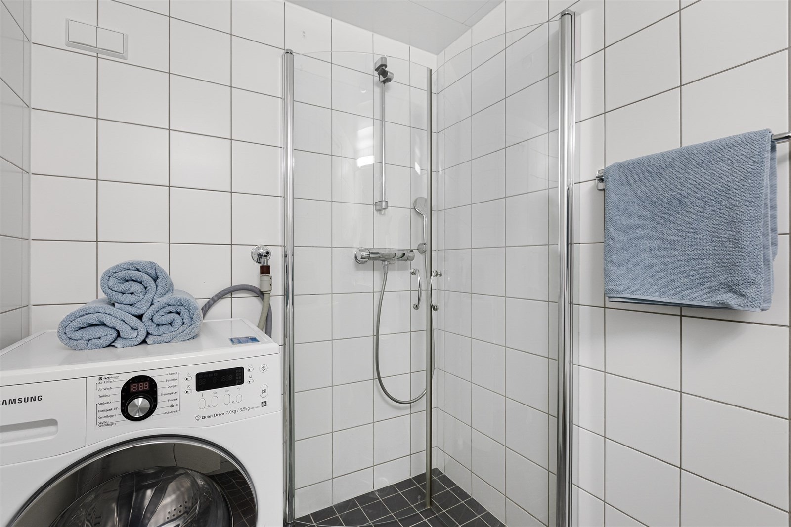 Videre består innredningen av servant med underskap, speil med overlys, dusjhjørne, og opplegg for vaskesøyle i hjørne. Galleribilde