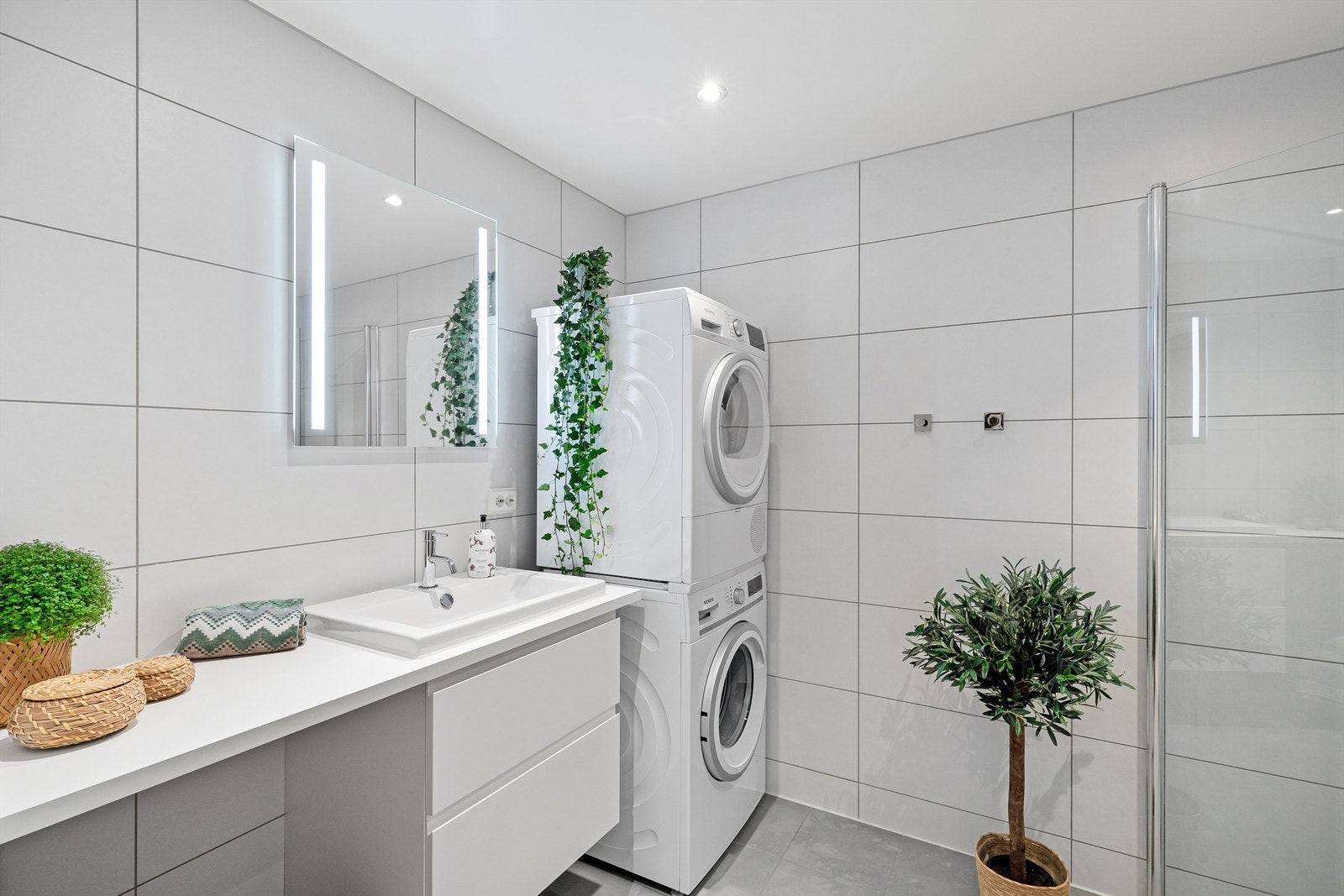 Romslig bad med dusj, wc, servant med underskap, speil med belysning samt opplegg for vaskesøyle. Galleribilde