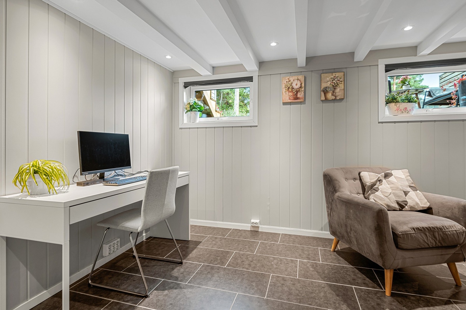 Deler av kjellerstuen benyttes i dag som hjemmekontor. Innenfor veggen bak PC'en er det en praktisk bod på 3 kvm. Galleribilde