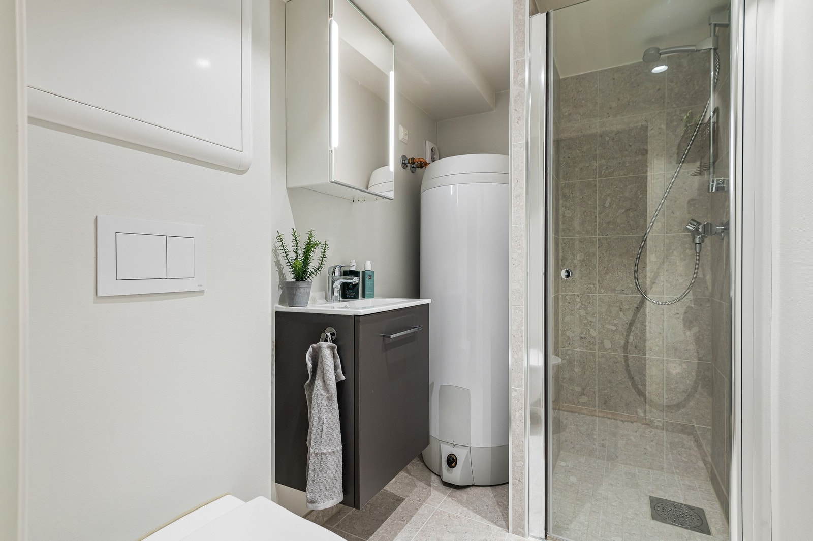 Badet i kjelleren er fra 2021 og er delvis flislagt med varmekabler i gulv. Også varmtvannsberederen er ny fra 2021. Galleribilde