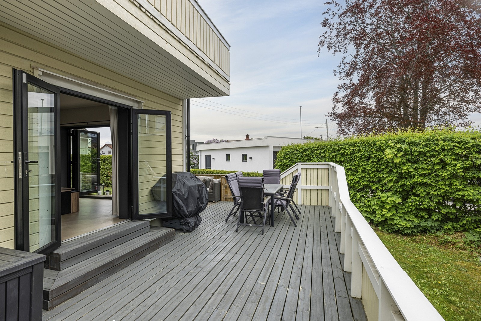 Utenfor stuen er det en stor terrasse med tregulv på hele 50 kvm, skjermet og privat beliggende til hagen på baksiden av boligen. Galleribilde