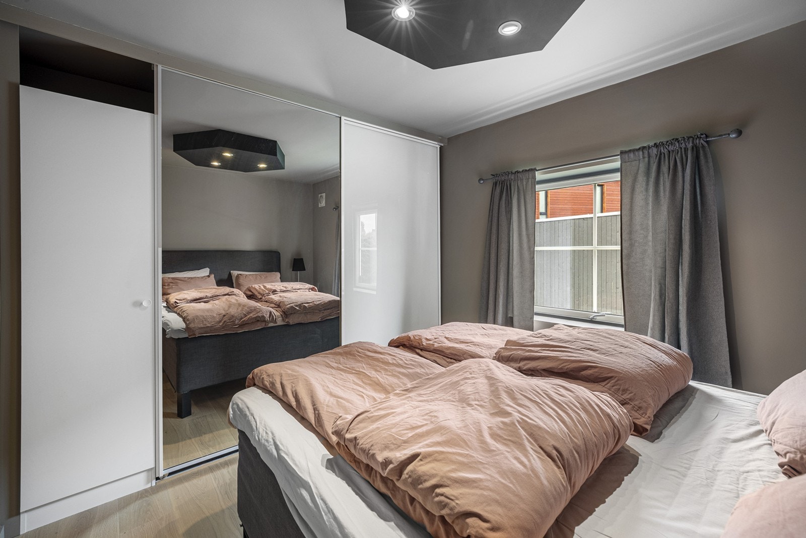 Soverom 1 - Soverommet i første etasje er et lyst og luftig rom som er malt i lun jordfarge. Soverommet har svært god oppbevaringsplass i en stor skyvedørsgarderobe. Galleribilde