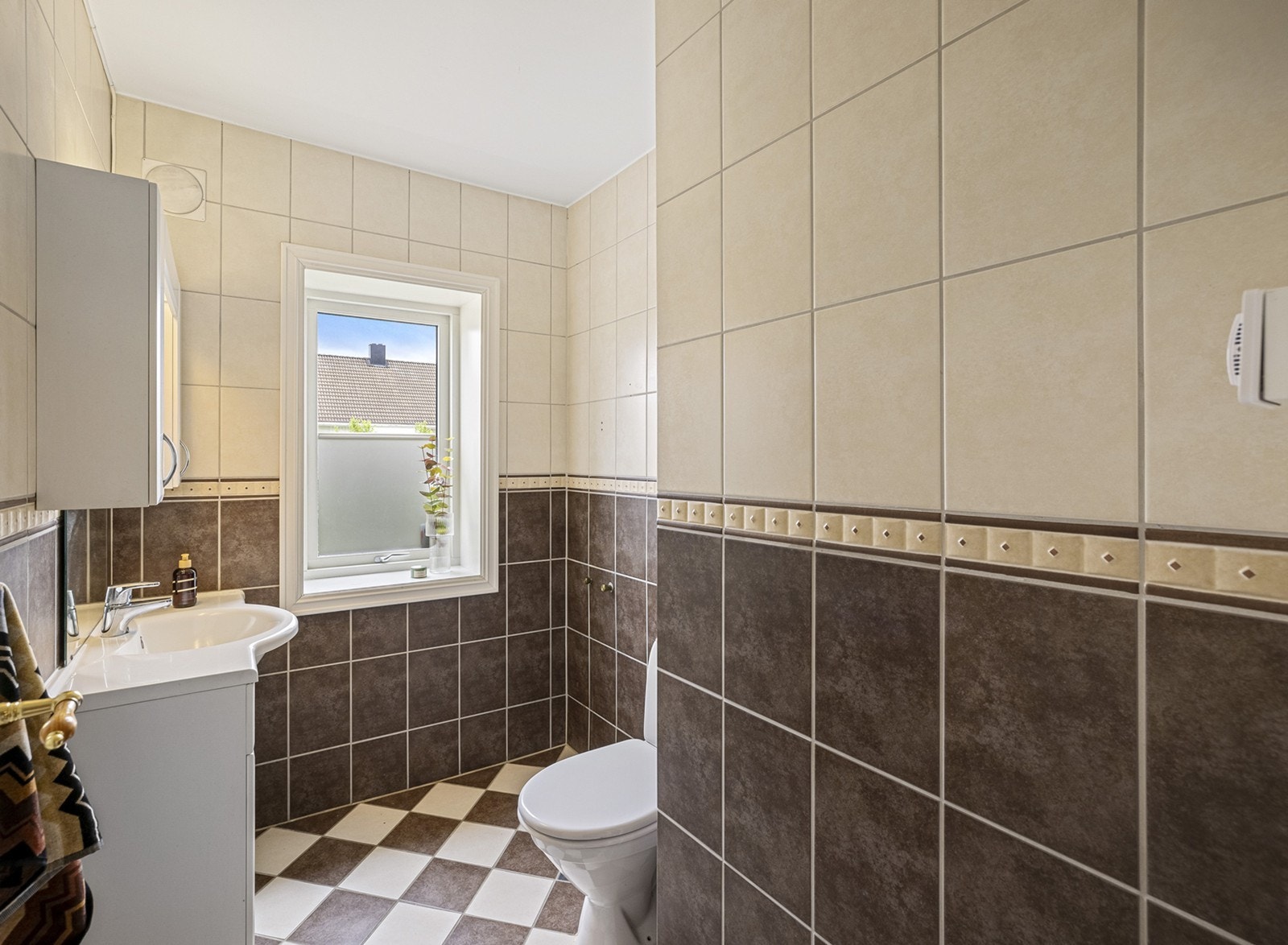 Et pent, flislagt toalettrom/gjestetoalett med gulvvarme. Innredningen består av vannklosett, underskap med servant, overskap, speil og armatur. Galleribilde