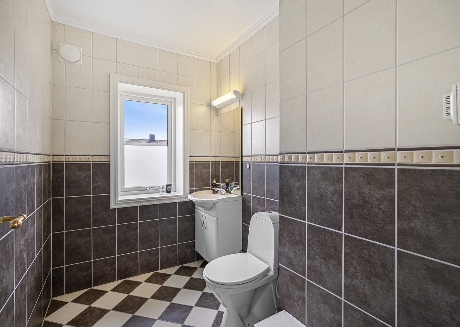 Et pent toalettrom finner du også i andre etasje, med flislagte vegger og gulv. Innredningen består av vannklosett, underskap med servant, speil og armatur. Galleribilde