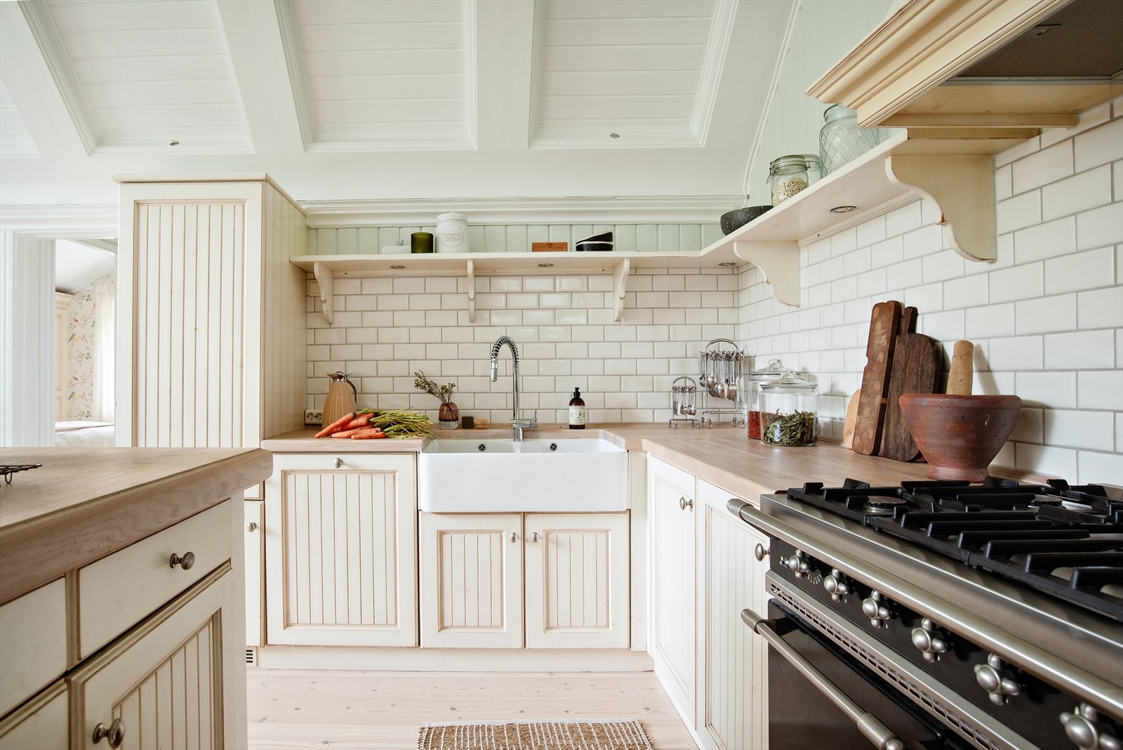 Benkeplate i heltre eik over kjøkkenøy og benkeplate i heltre eik med underlimt dobbel hvit keramisk vaskekum med ettgreps blandebatteri i rustfritt stål med uttagbar munnstykke. Galleribilde