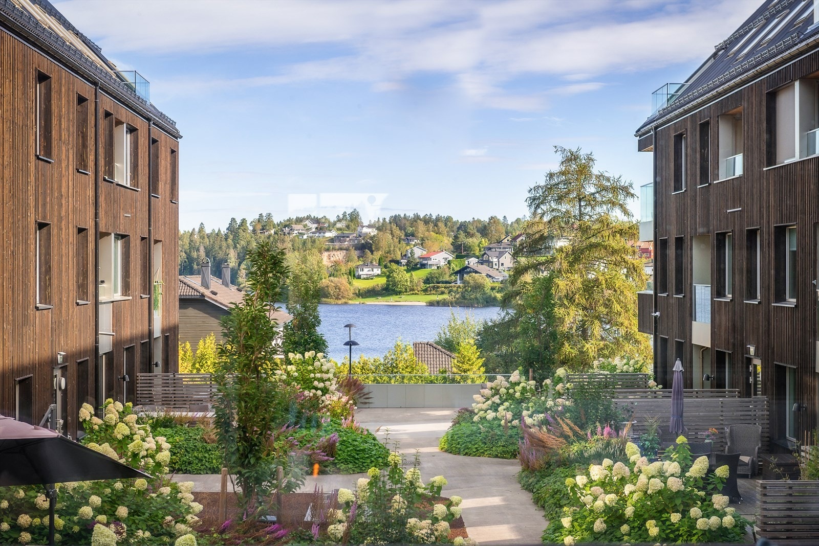 Fellestomten er opparbeidet med blant annet belegningsstein, trær og diverse beplantning. Galleribilde