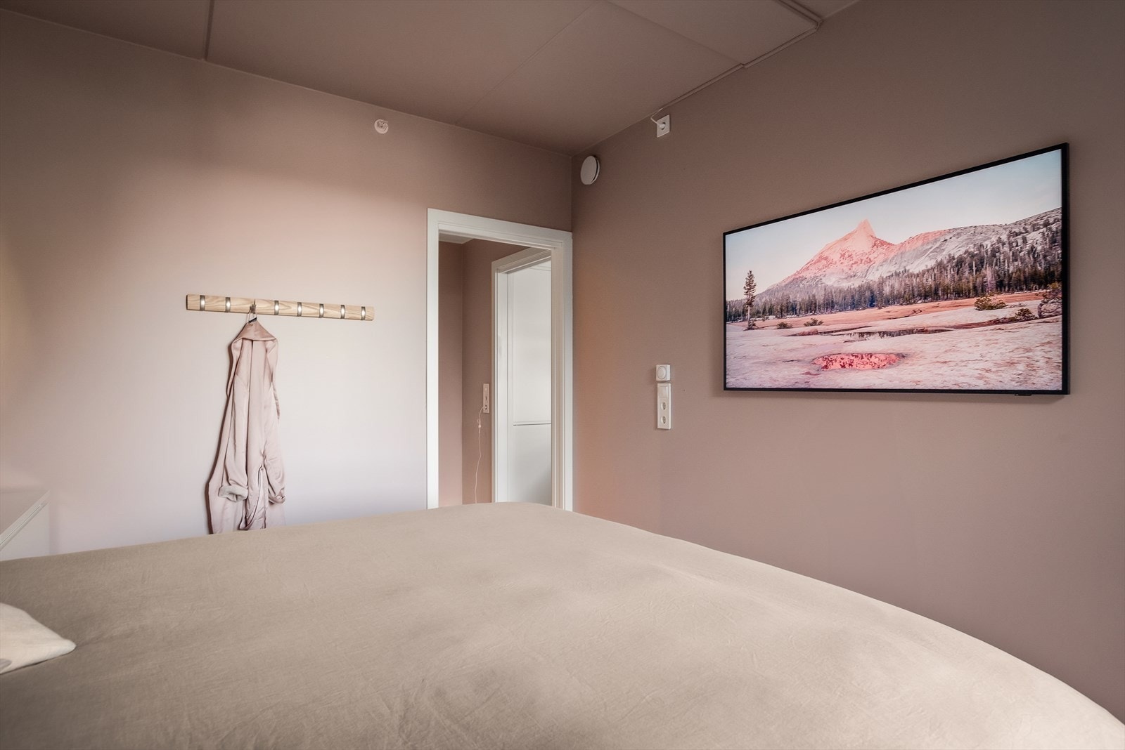 Rommet er innredet med dobbeltseng og nattbord Galleribilde