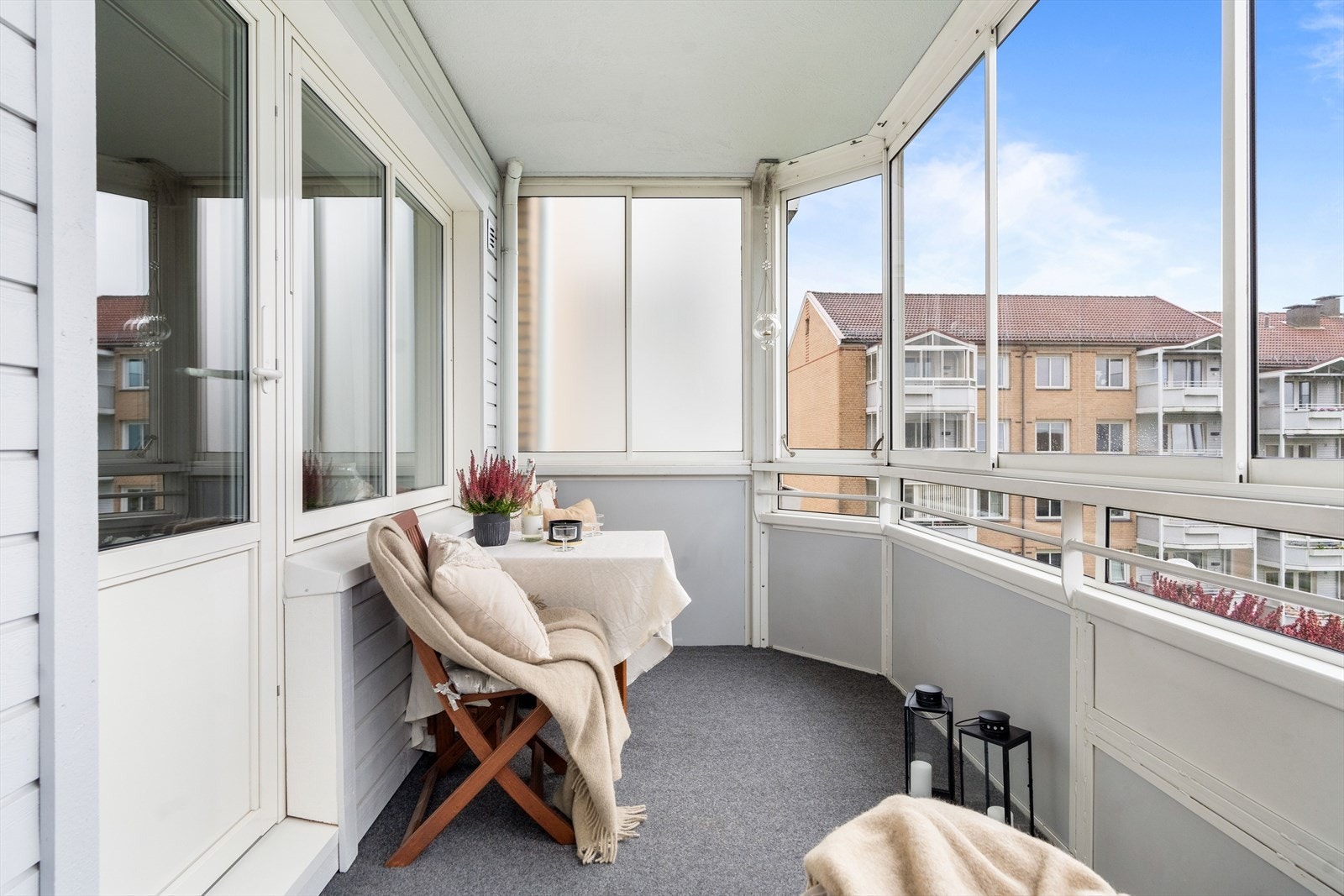 Balkongen har betonggulv dekket med et teppegulv som gir en lun atmosfære. Innglassingen kan åpnes og skyves til side for å åpne opp og tilpasse ette været. Galleribilde