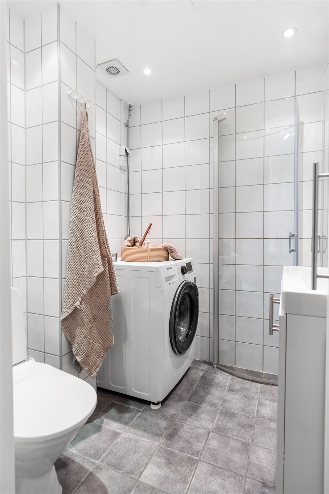 Pent flislagt bad med varme i gulv. Her er det servantskap, toalett og dusjhjørne med innsvingbare dusjdører. Galleribilde