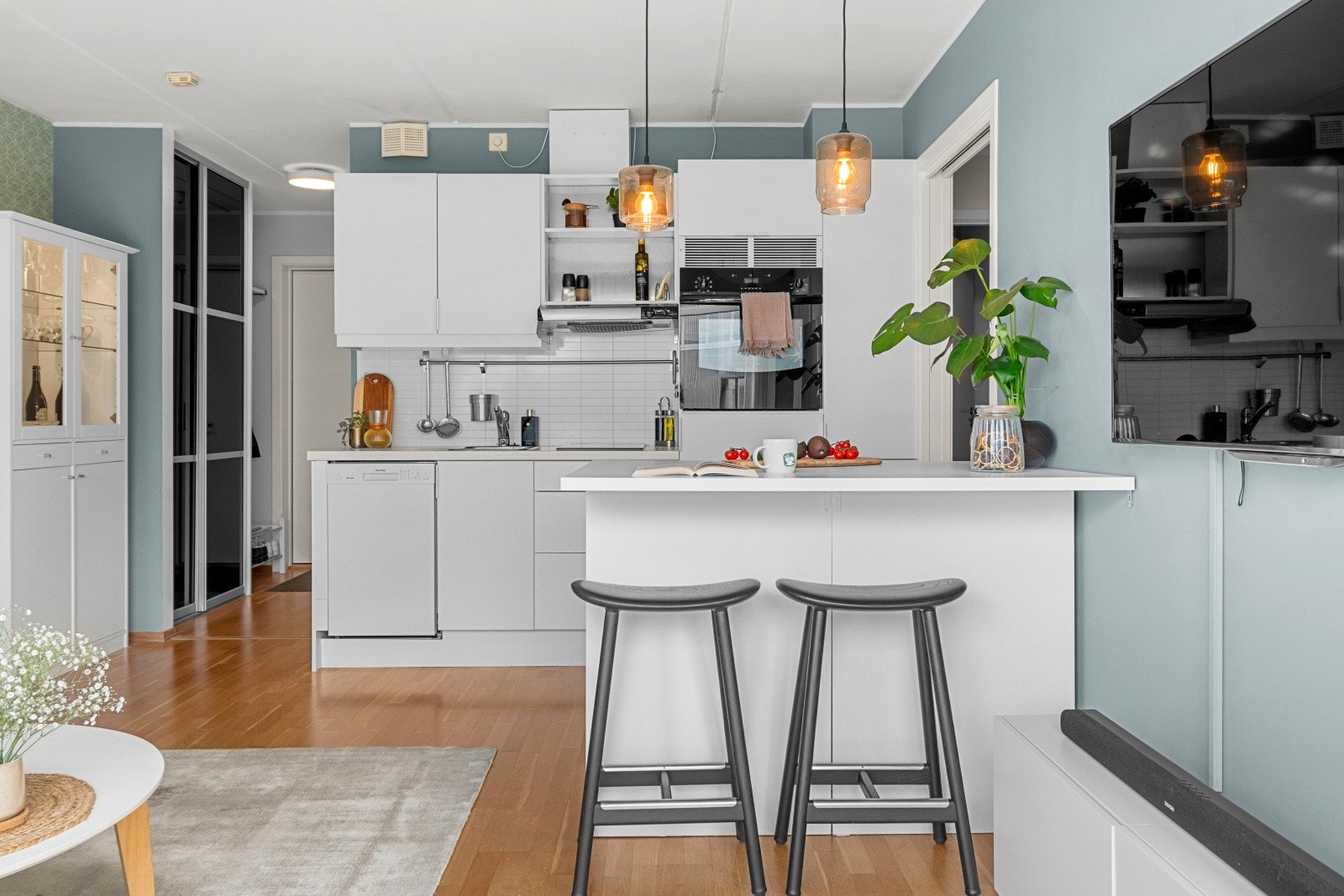 Pent kjøkken i åpen løsning med stuen - Praktisk kjøkkenøy med sittemuligheter Galleribilde