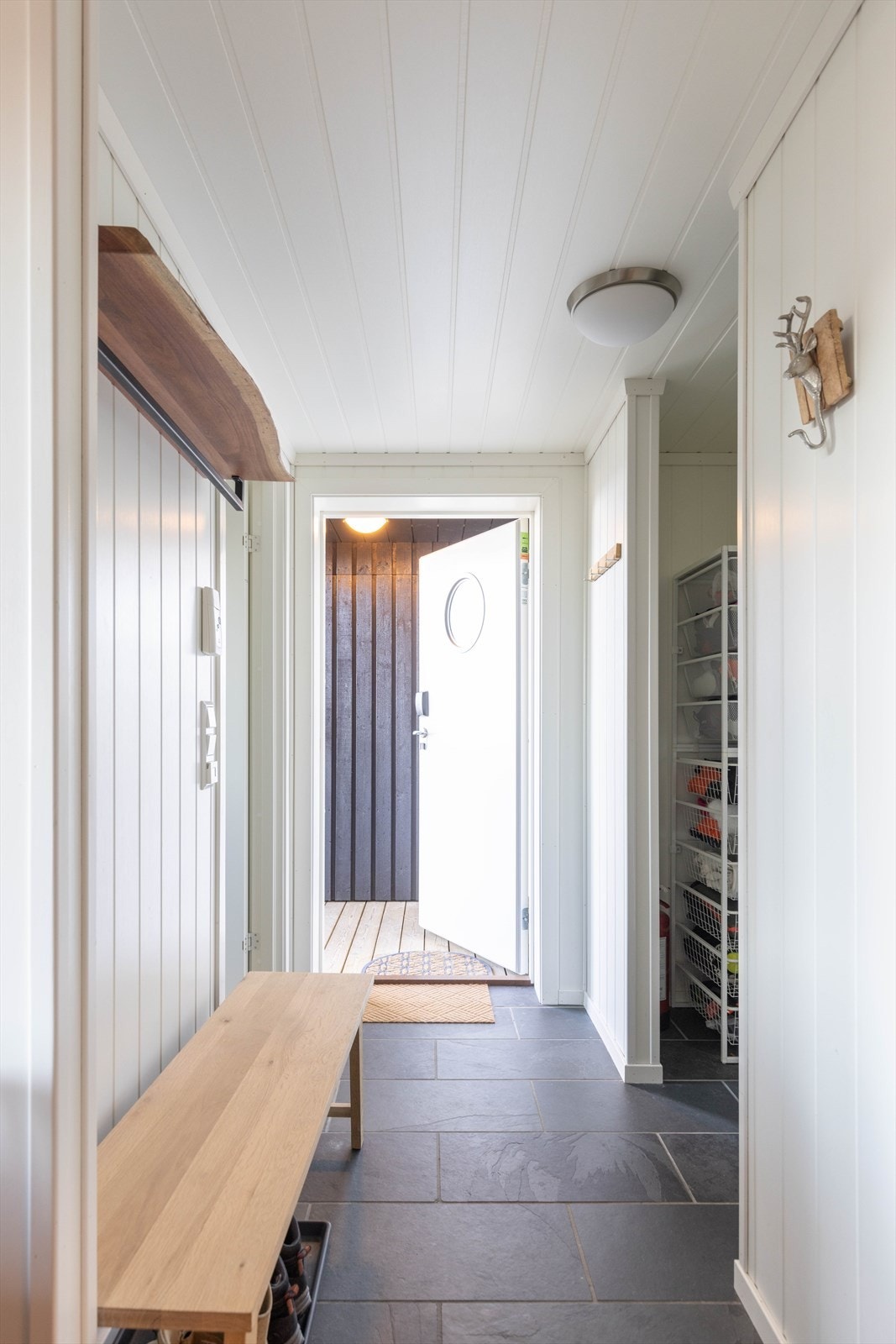 Du møtes av en flislagt entré som leder inn til stue, soverom og et WC-rom Galleribilde