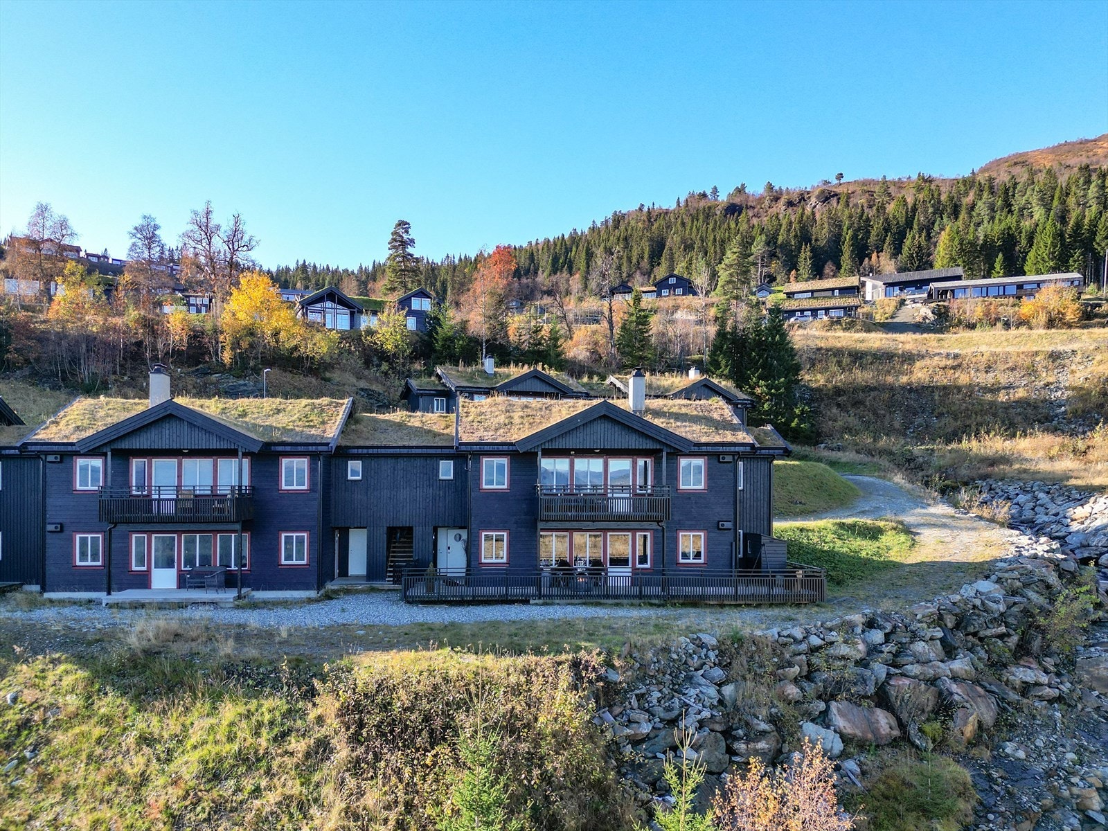 Det er egen vedbod på utsiden. Her kan man også oppbevare bålpanne og grill Galleribilde