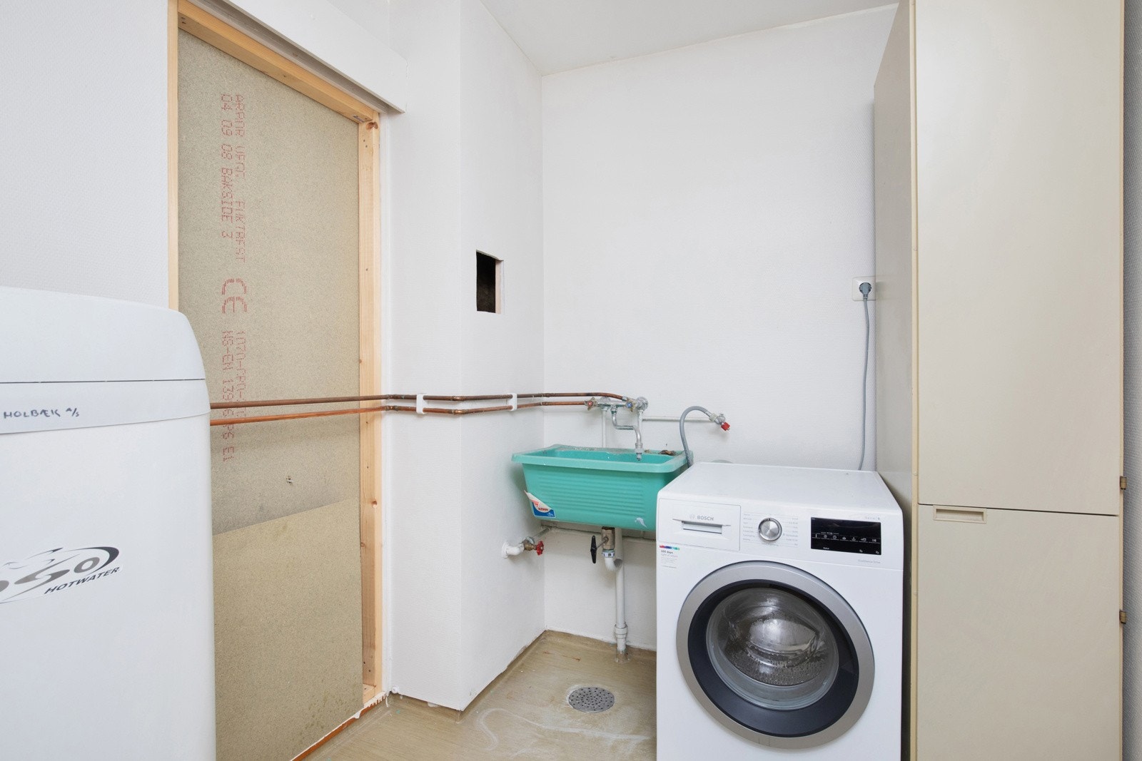 Vaskerom med utslagsvask og opplegg for vaskemaskin. Galleribilde