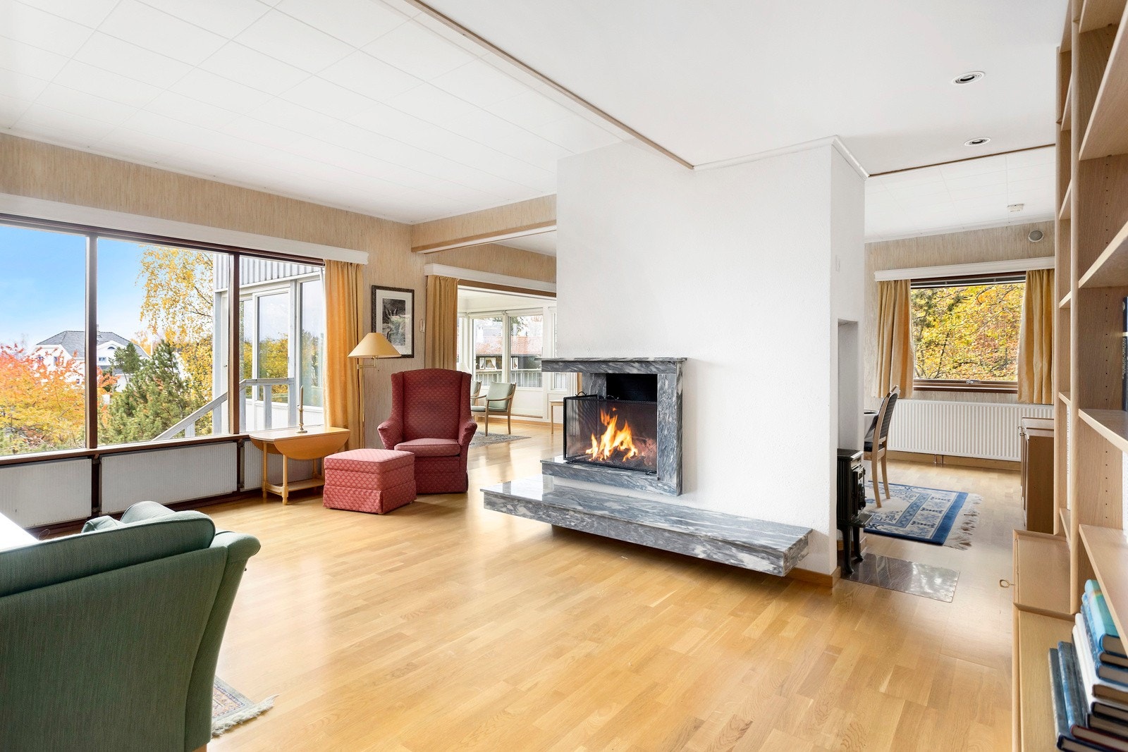 Peis i stuen med marmor omramming, Jøtul ovn på siden av peisen. Galleribilde