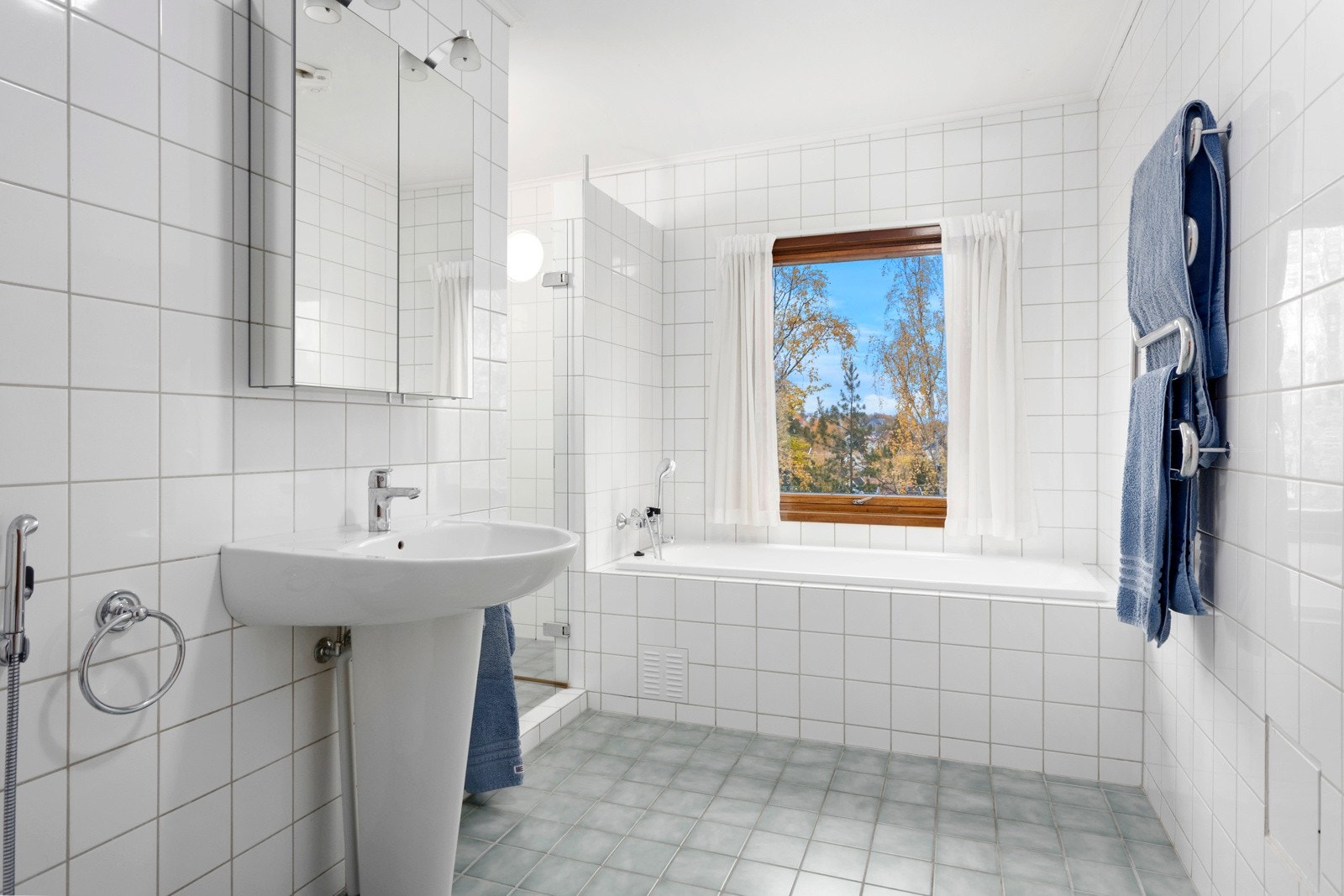 Baderom med wc, bidet, søyleservant, innmurt badekar, og dusj i hjørne. Galleribilde