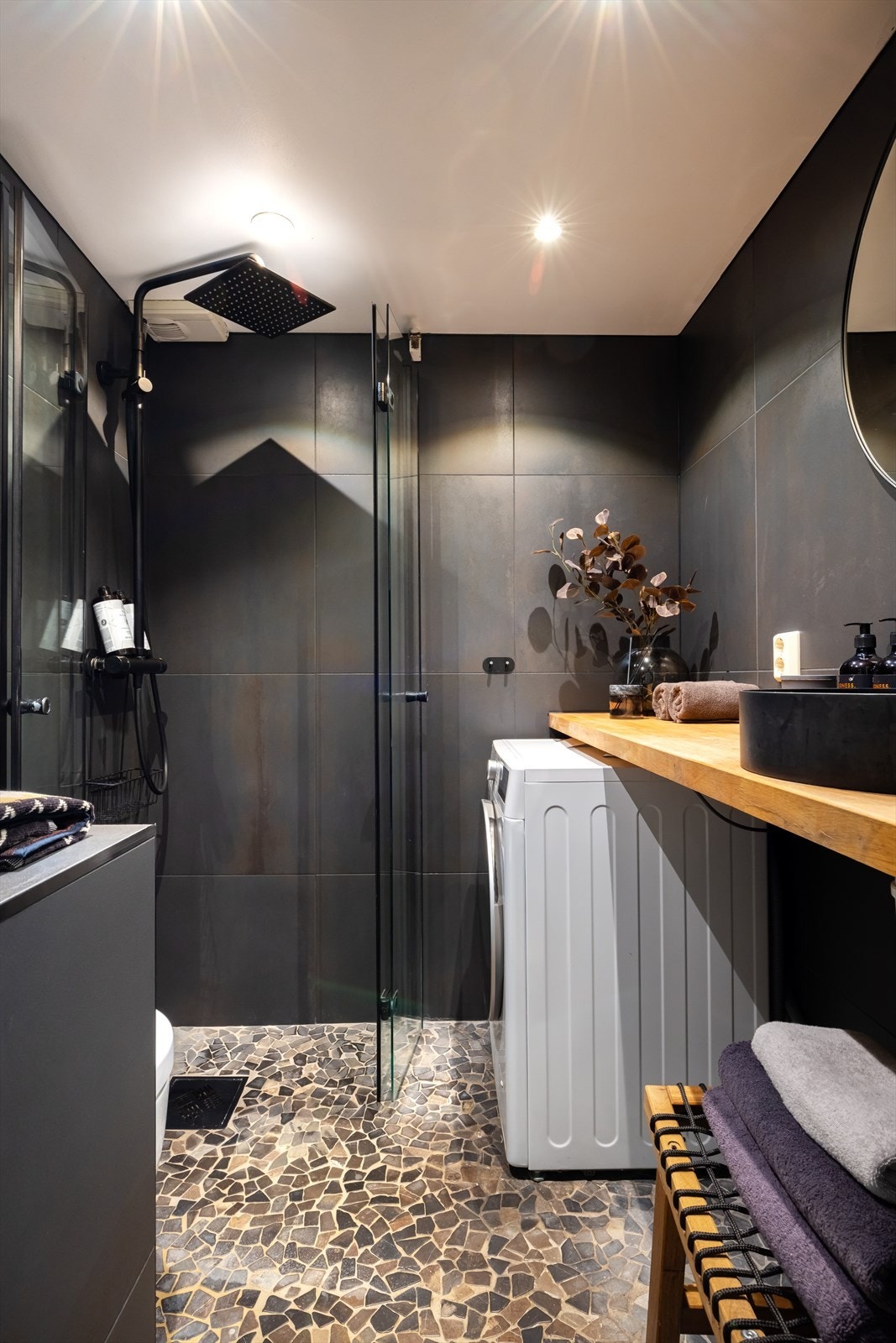 Badet har dusjhjørne med regnfallsdusj, vegghengt toalett, samt servant på benk. Galleribilde