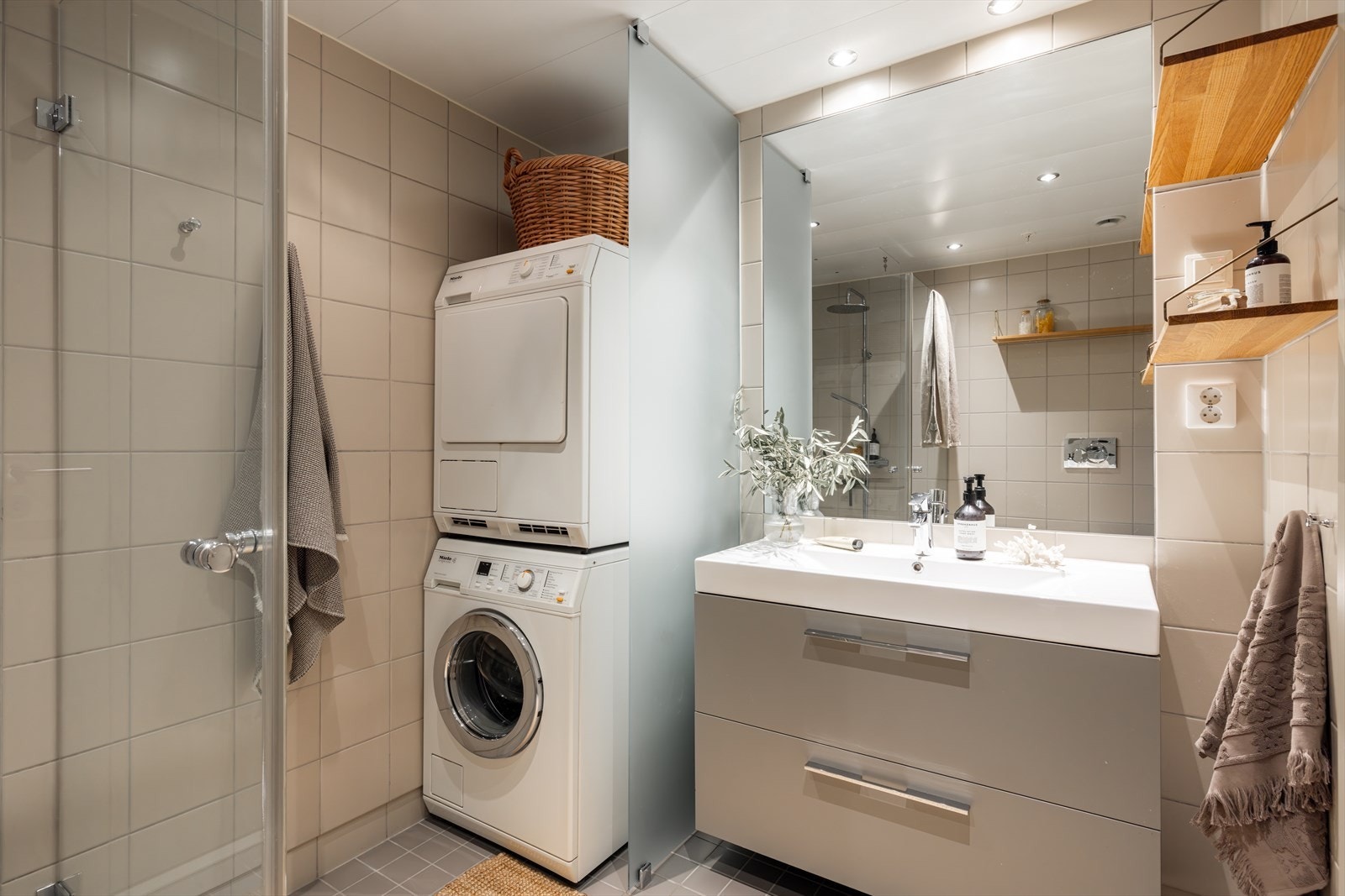 Badet består av vegghengt toalett med innebygd sisterne, servant på vegghengt servantskap og dusj med innfellbare dører i herdet glass Galleribilde