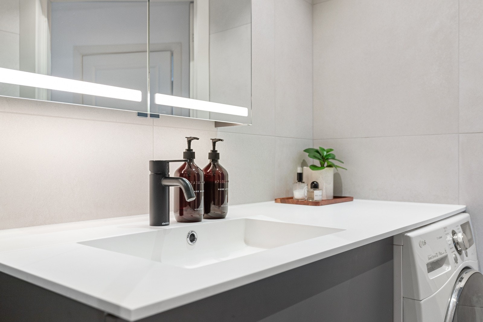 Badet har ovenpåliggende servant med armatur og speilskap med lys. Galleribilde