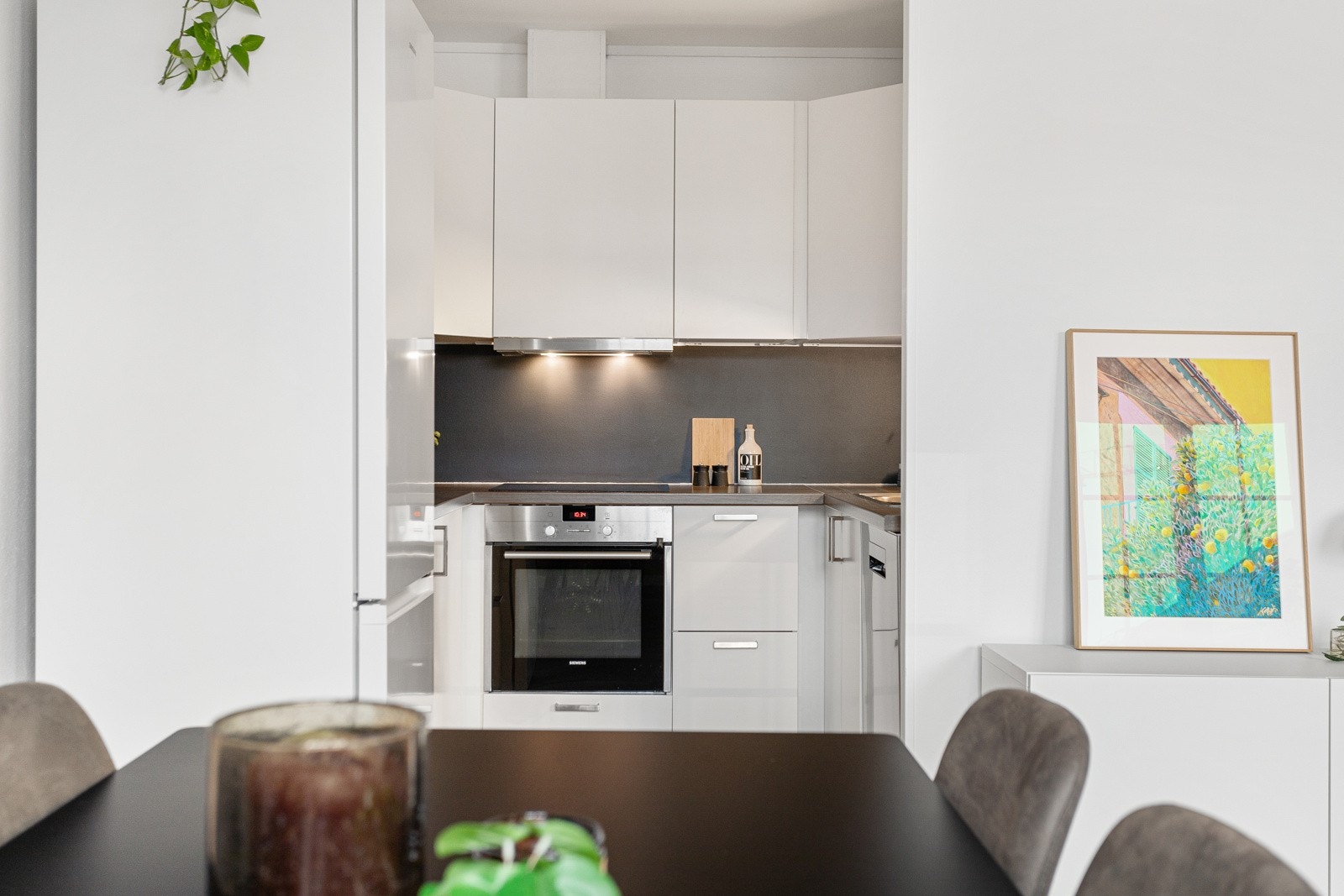 Kjøkkenet er innredet med glatte fronter og benkeplate av laminat. Galleribilde